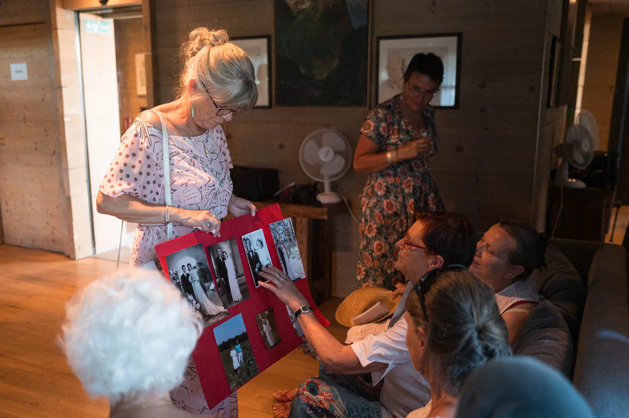Groupe de personnes âgées regardant des photos sur un tableau lors d'une réunion en intérieur