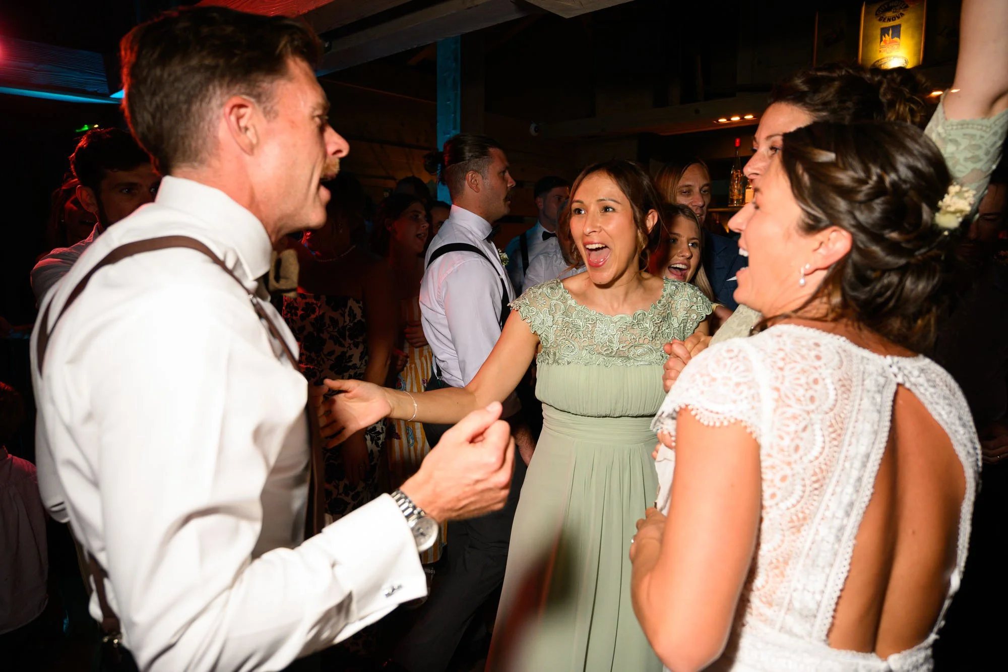 Un groupe de personnes célébrant joyeusement lors d'une fête ou d'un mariage, dans une ambiance festive et conviviale.