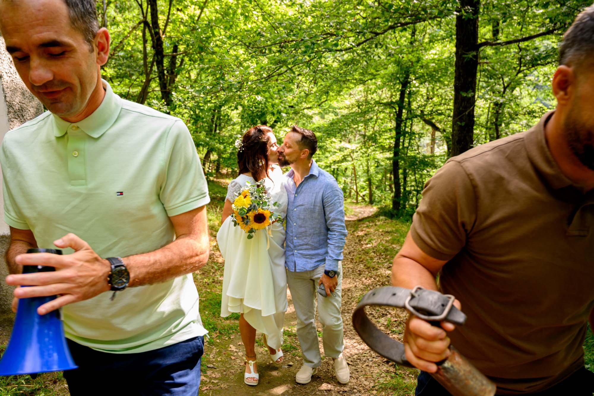 Un couple qui s'embrasse dans la forêt, entouré de deux hommes qui tiennent un mégaphone et une tronçonneuse.