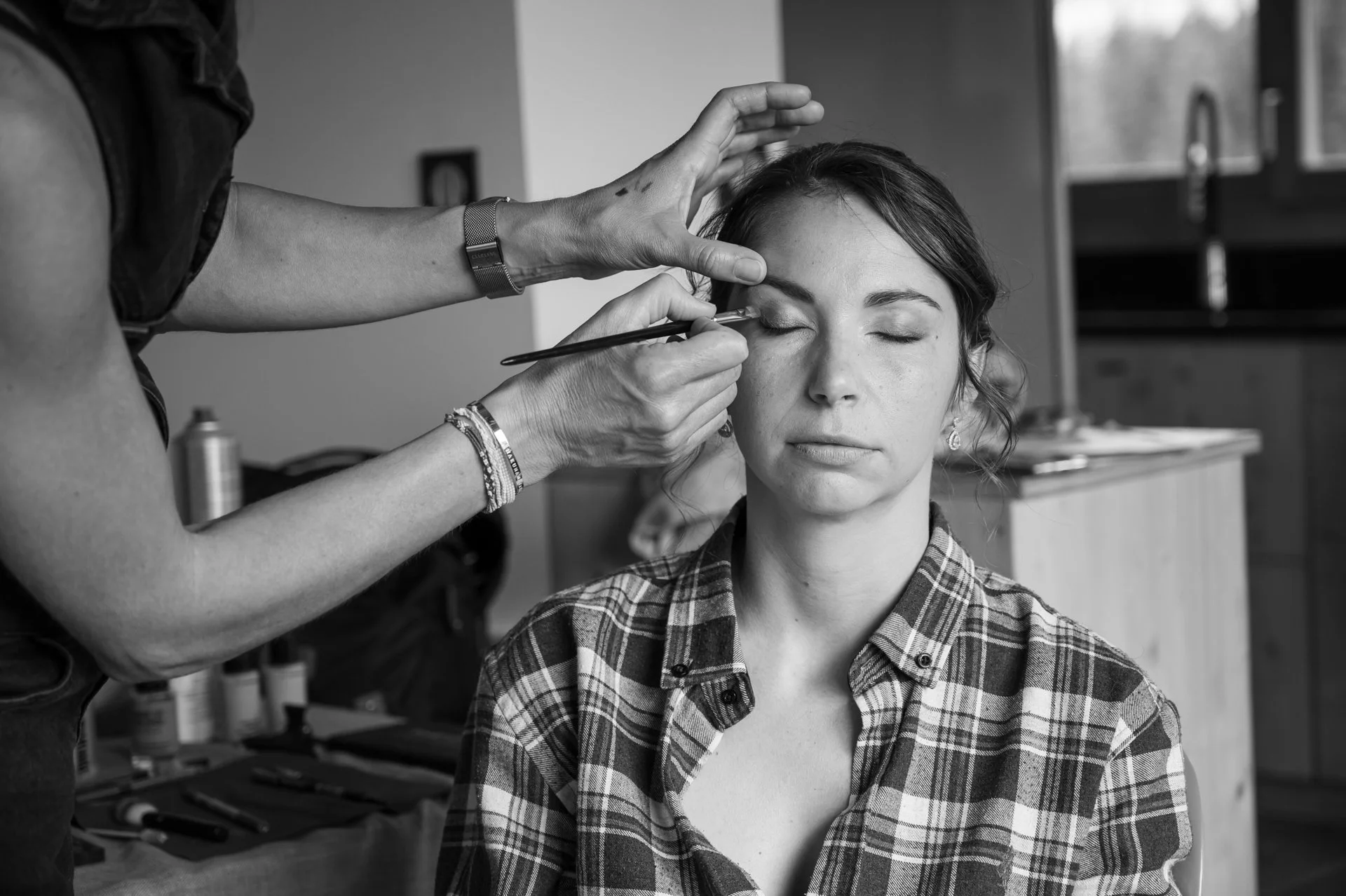 Femme faisant faire un maquillage à une autre femme avec ses yeux fermés