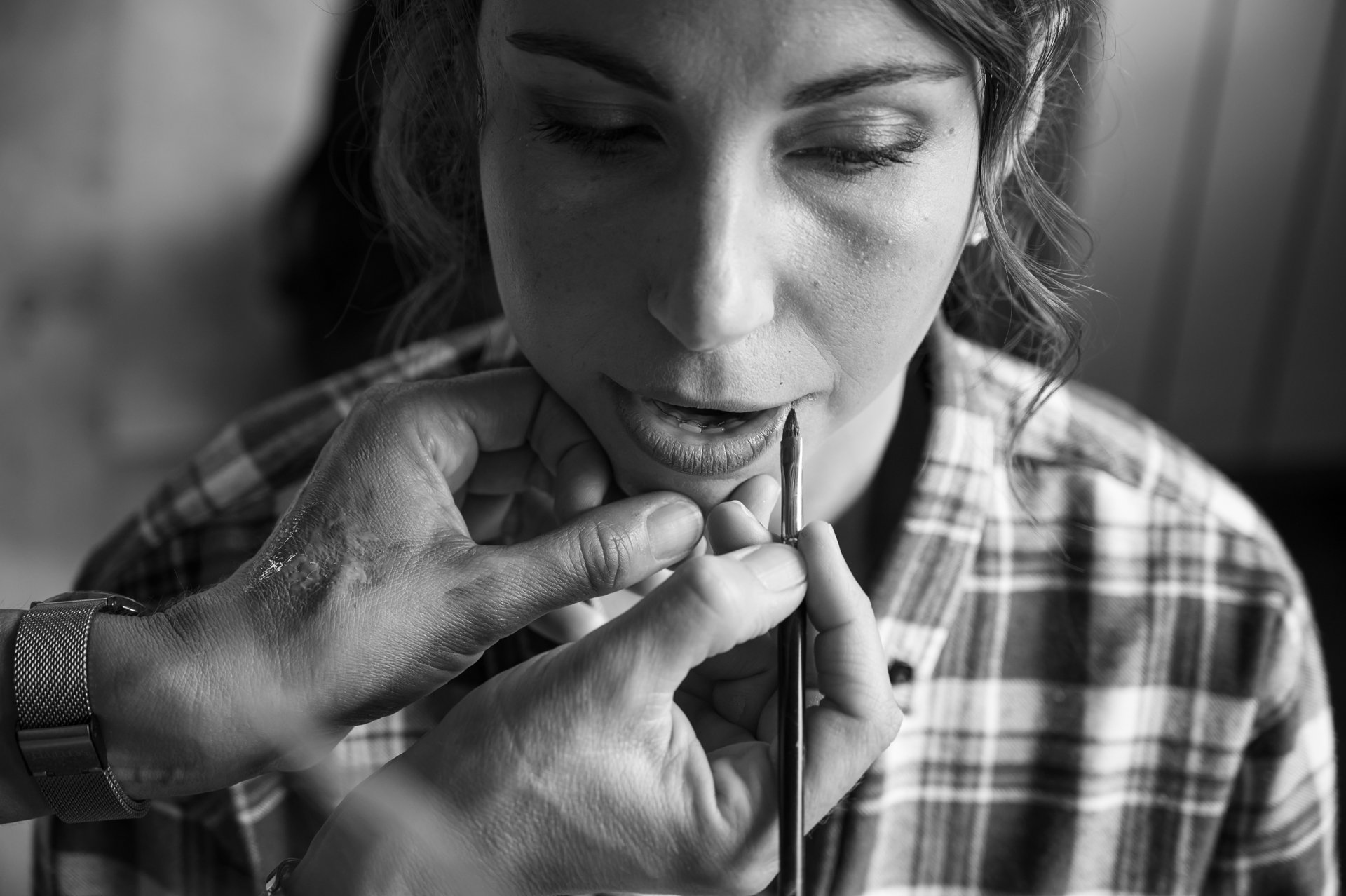 Une femme reçoit un tatouage au maquillage permanent, un professionnel utilise un stylo pour appliquer la pigmentation sur ses lèvres dans un studio de tatouage.