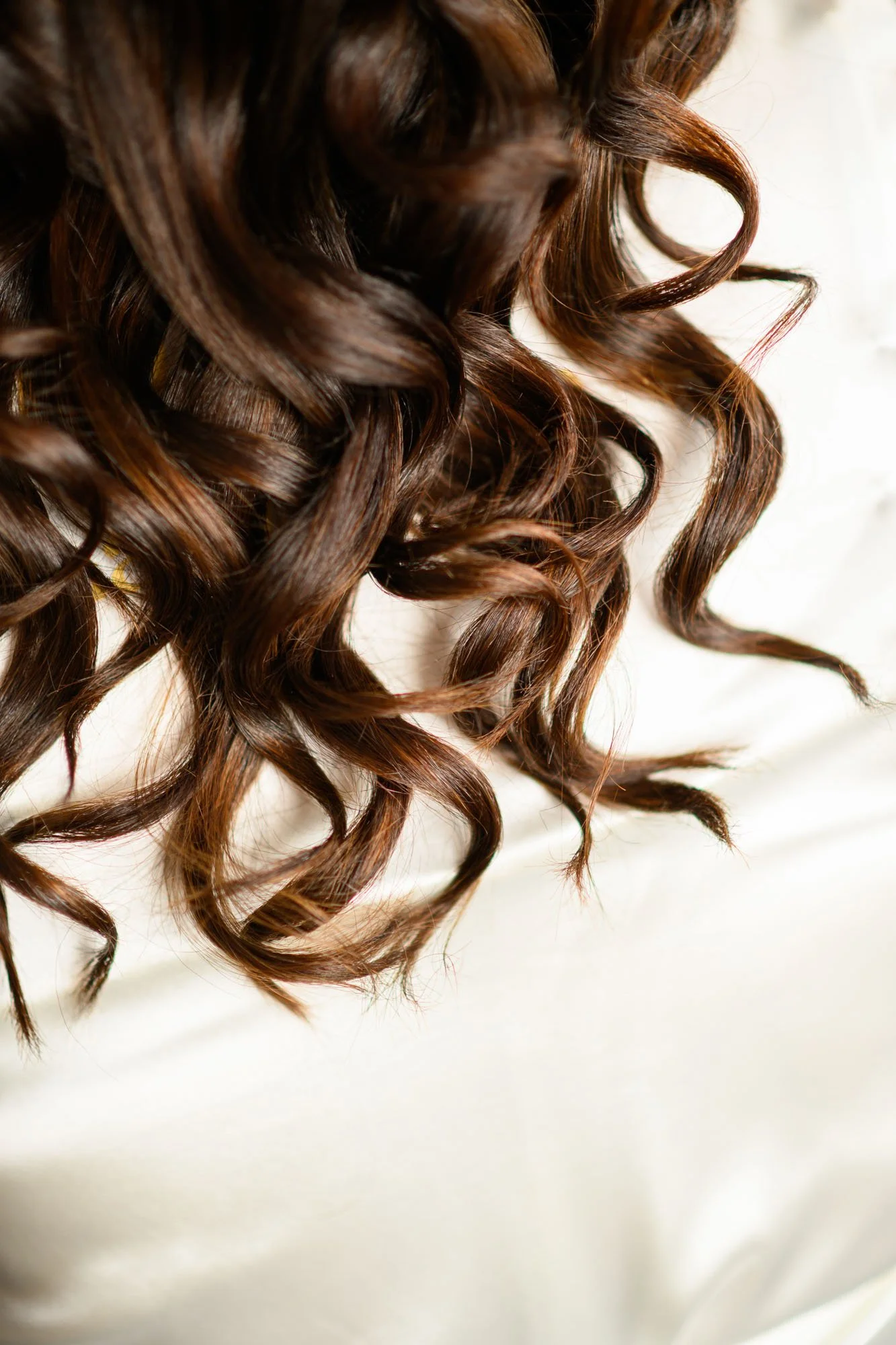 Cheveux longs, bouclés, bruns.