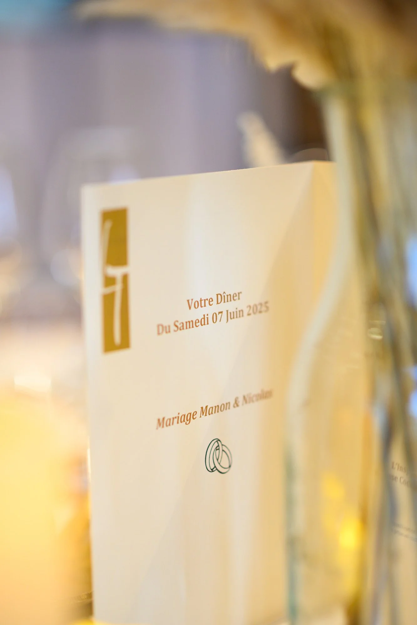 Menu de dîner de mariage avec la date 7 juin 2025, pour Manon et Nicolas, avec une illustration de deux anneaux entrelacés.
