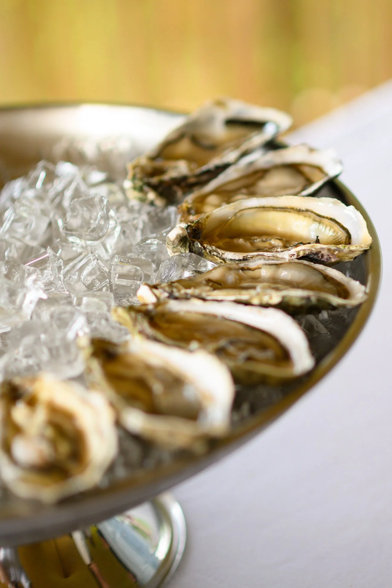 Coquilles d'huîtres sur un lit de glace dans un plat en argent.
