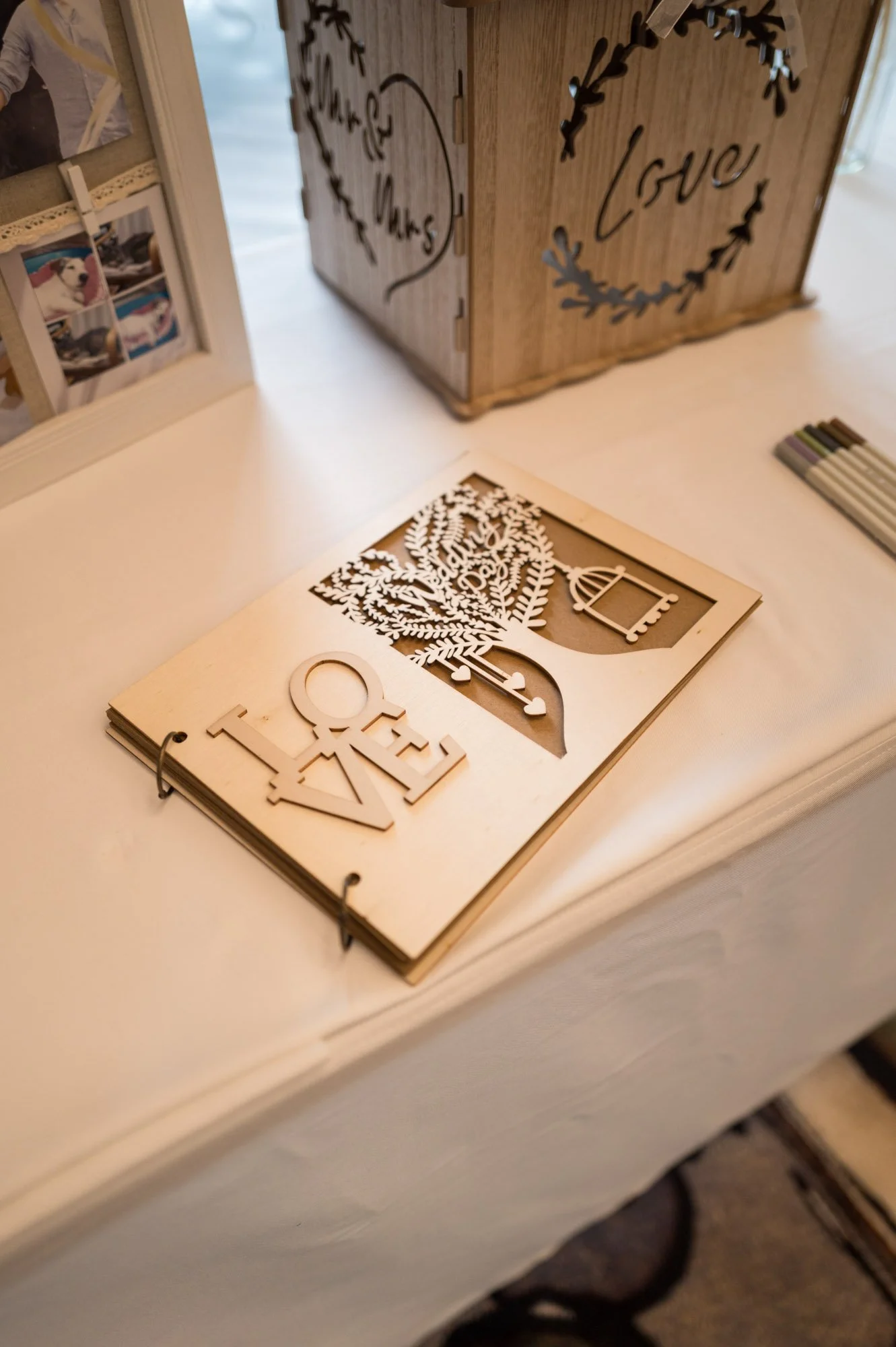 Livre en bois gravé avec le mot "LOVE" et un arbre stylisé, posé sur une table.