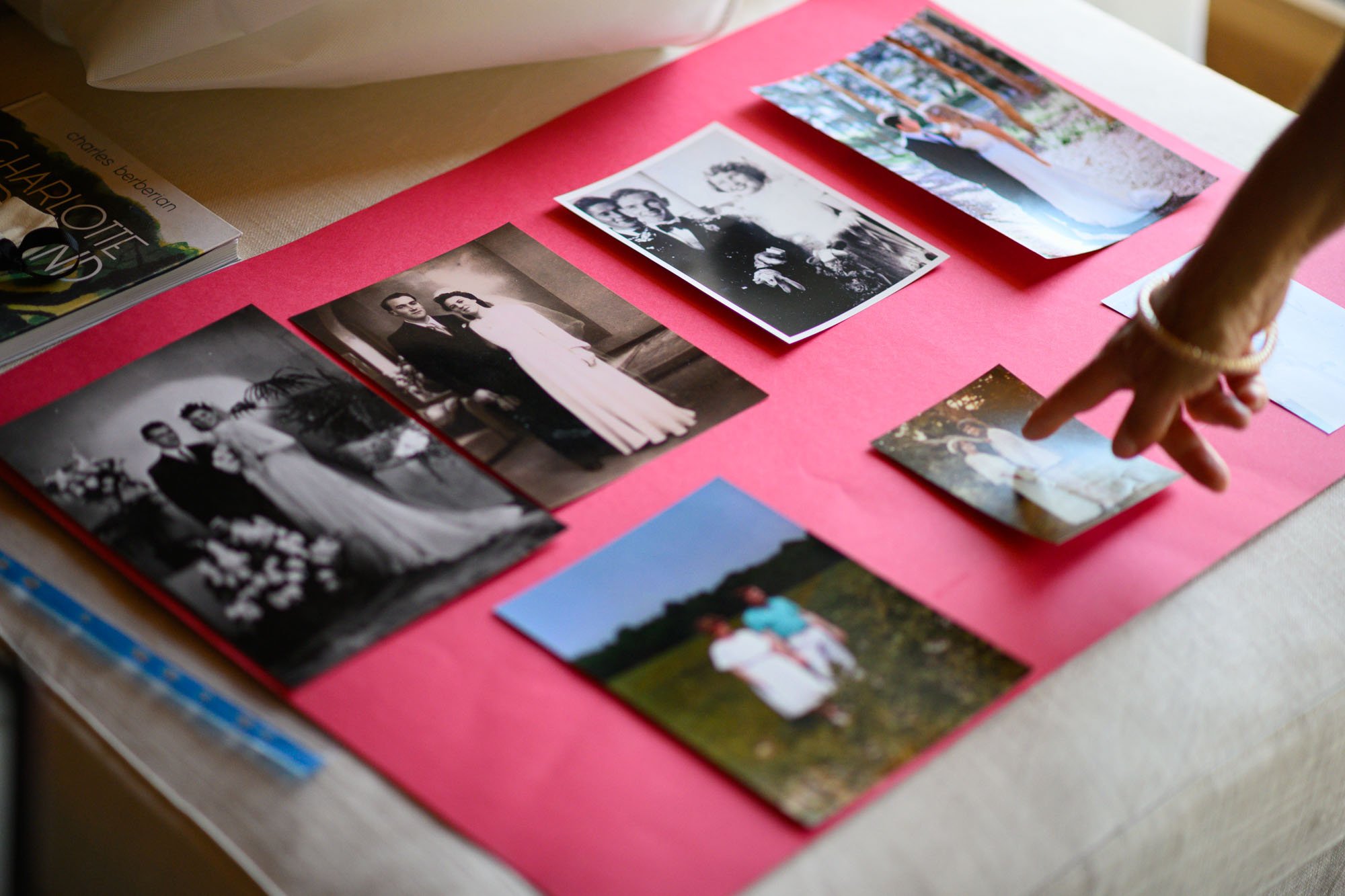 Tableau avec plusieurs photos de famille, dont certaines en noir et blanc, et une personne pointant une photo positive.