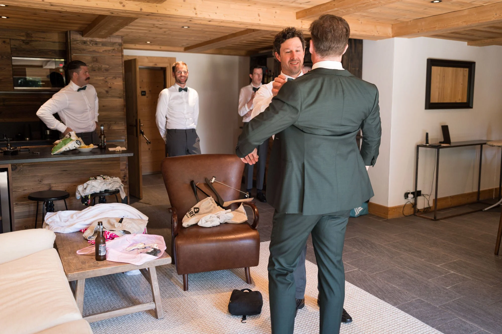 Groupe d'hommes en costume dans un salon, semblait se préparer pour un événement ou une célébration.