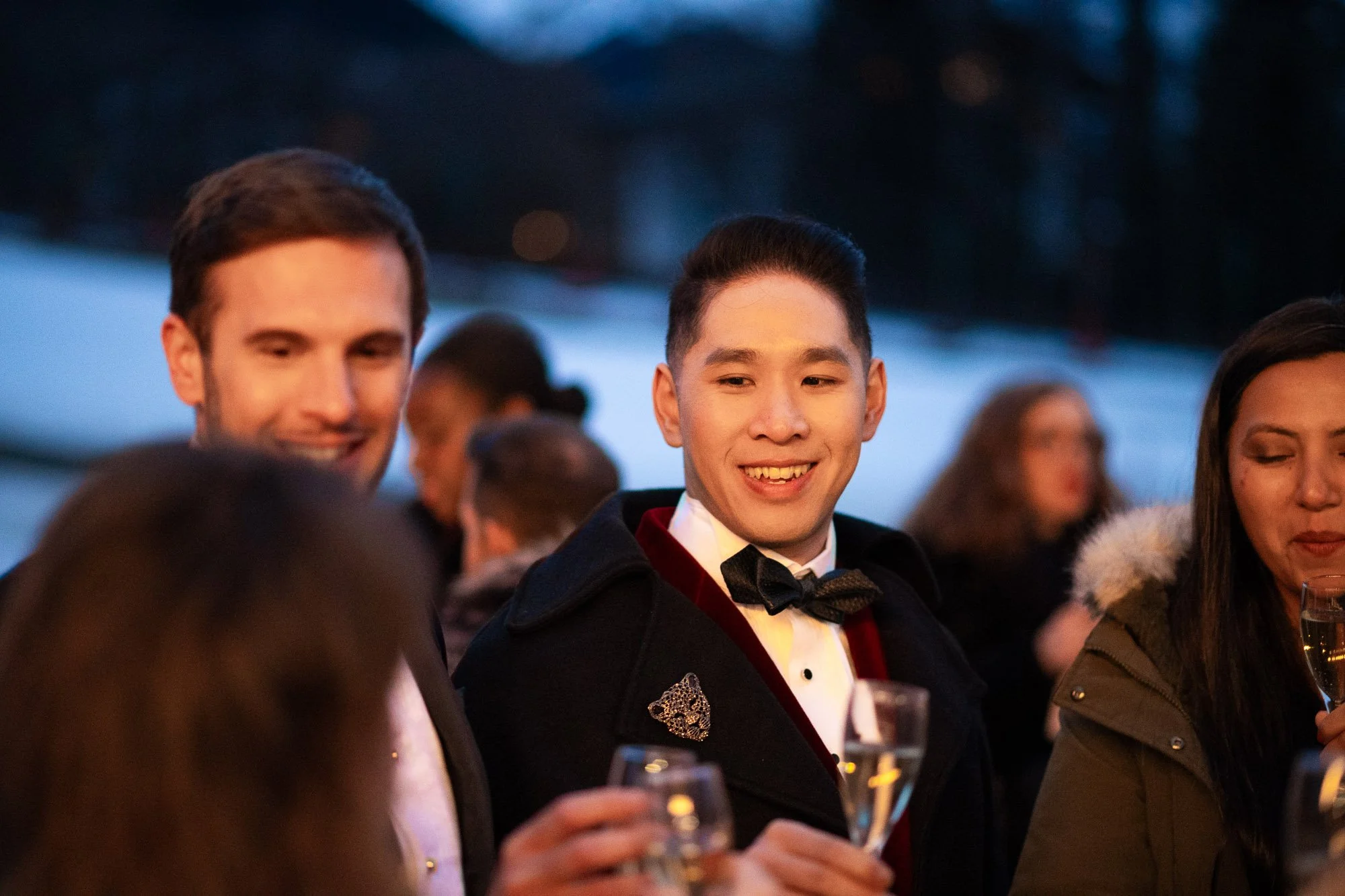 Group d'amis en soirée élégante, certains avec des vestes formelles, portant des flûtes de champagne