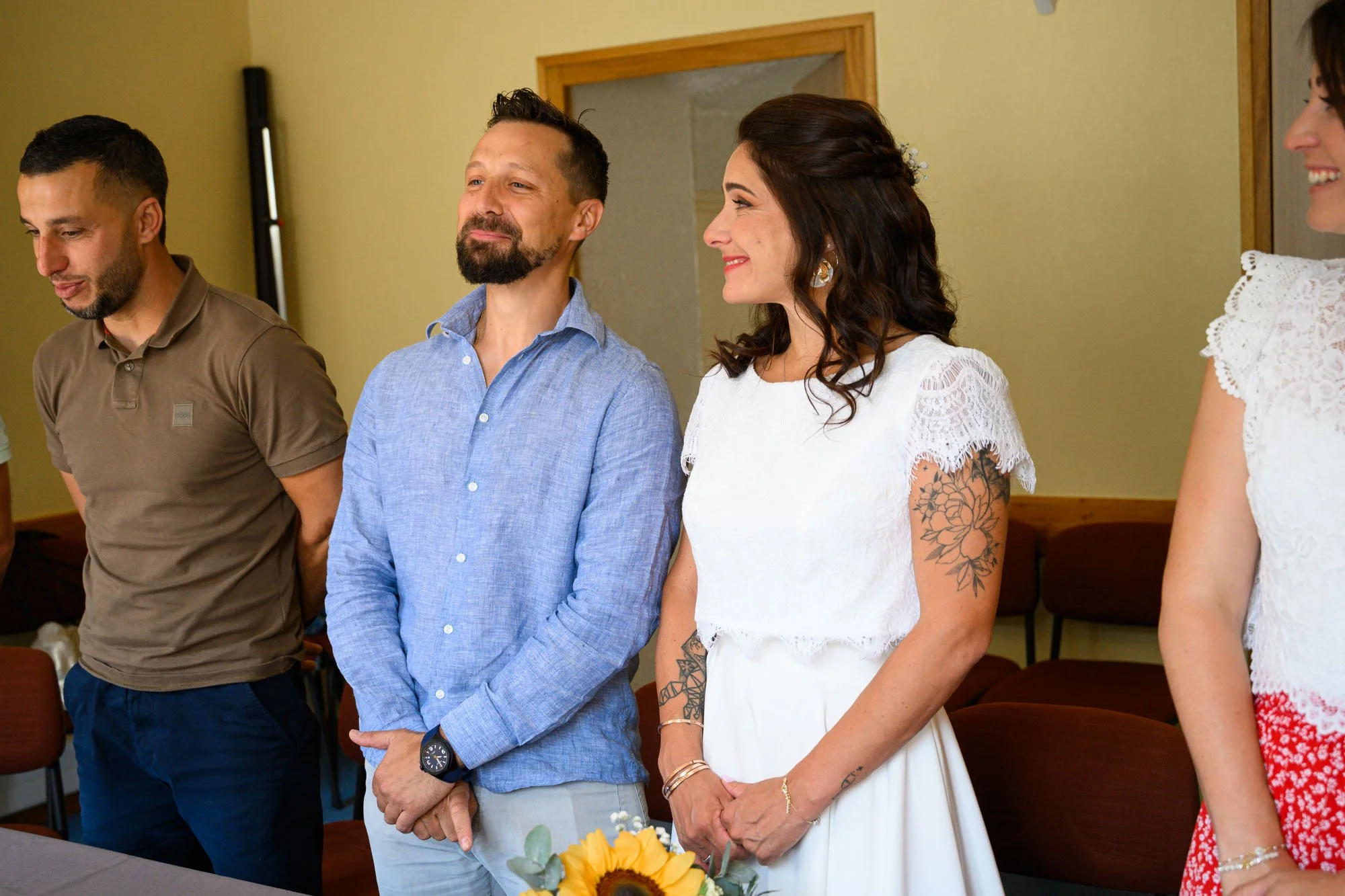 Groupe de personnes lors d'une cérémonie, debout en ligne, souriantes, dans une salle au style chaleureux.