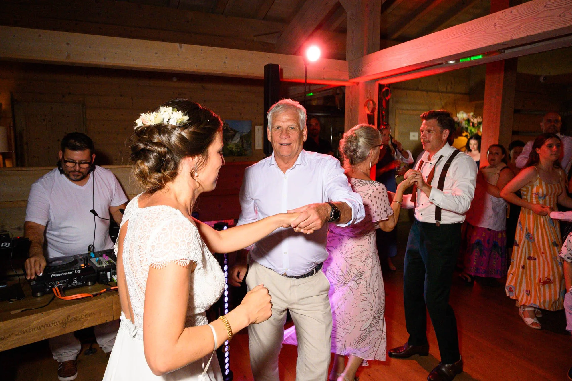 Groupe de personnes dansant lors d'une fête dans une salle en bois