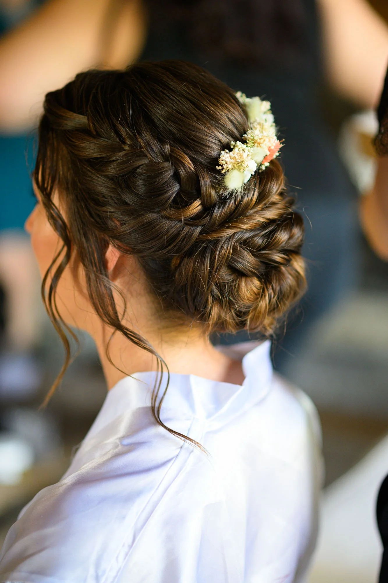 Coiffure de mariage avec tresse et cheveux relevés ornés de petites fleurs