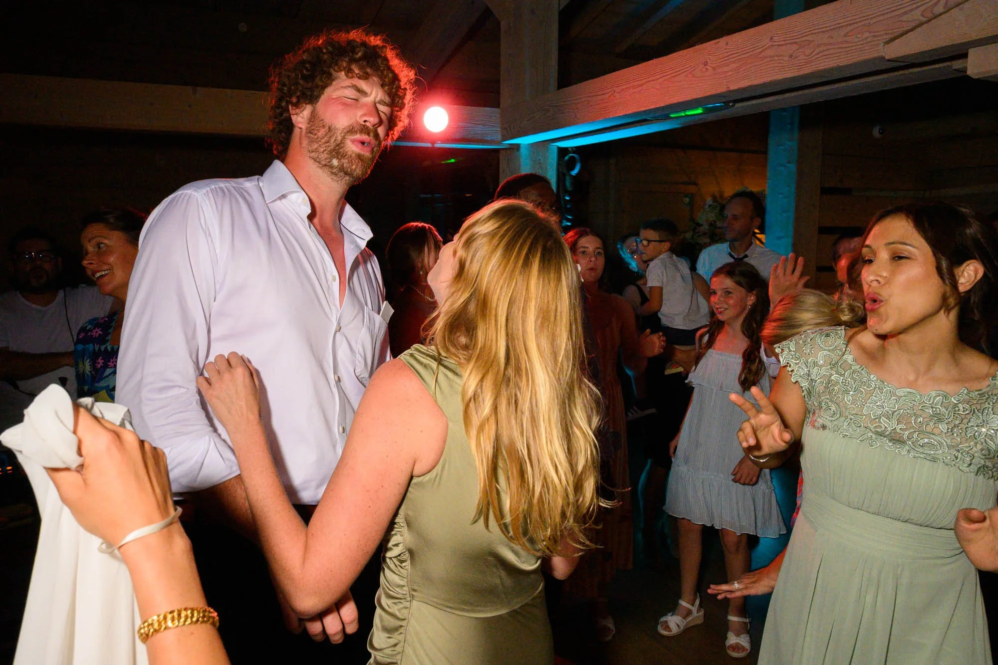 Groupe de personnes dansant lors d'une fête ou d'un événement social, ambiance animée et conviviale.
