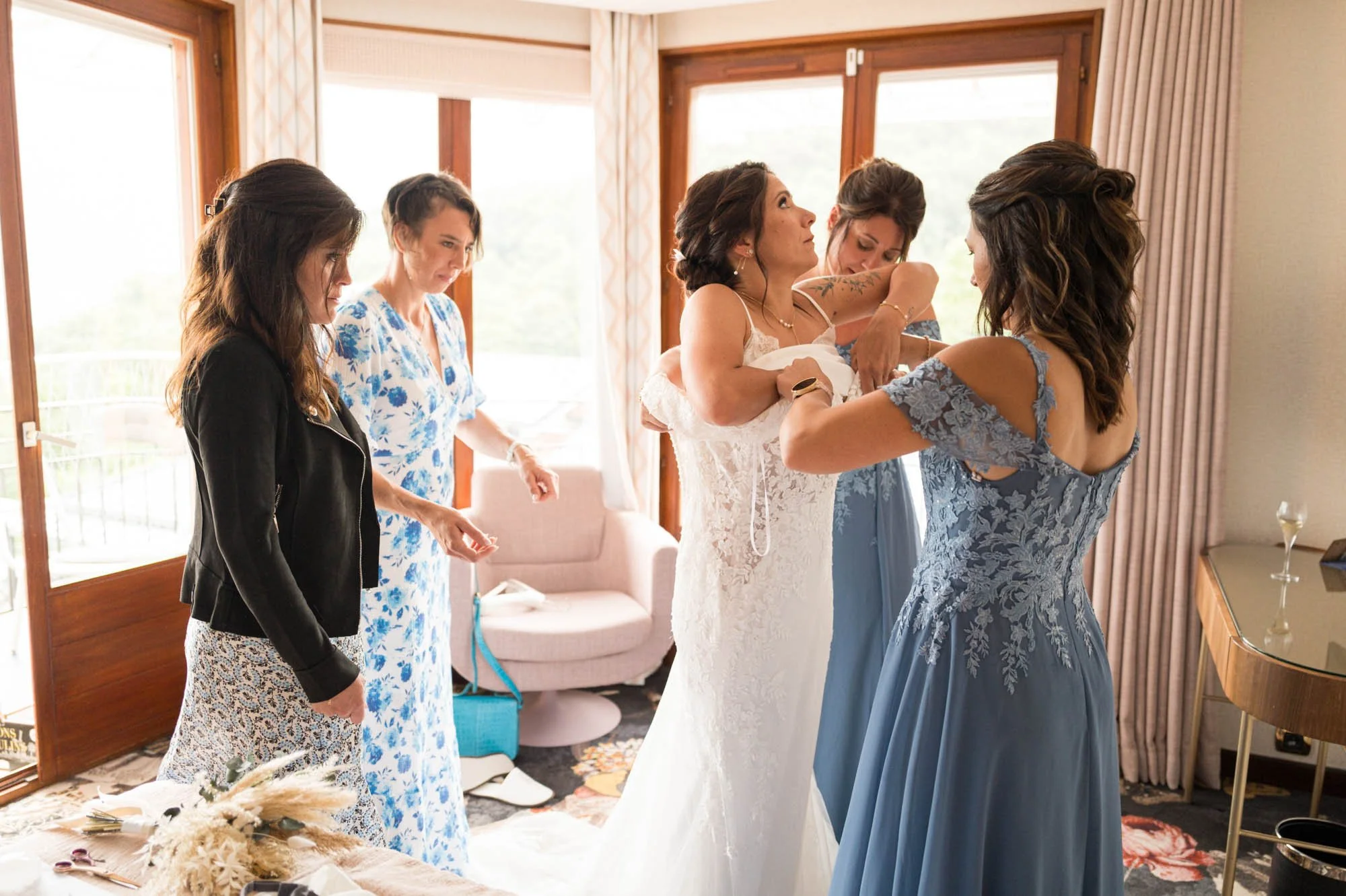 Femmages en robe de mariage et robes de demoiselles d'honneur dans une chambre, en train de se préparer pour un mariage.
