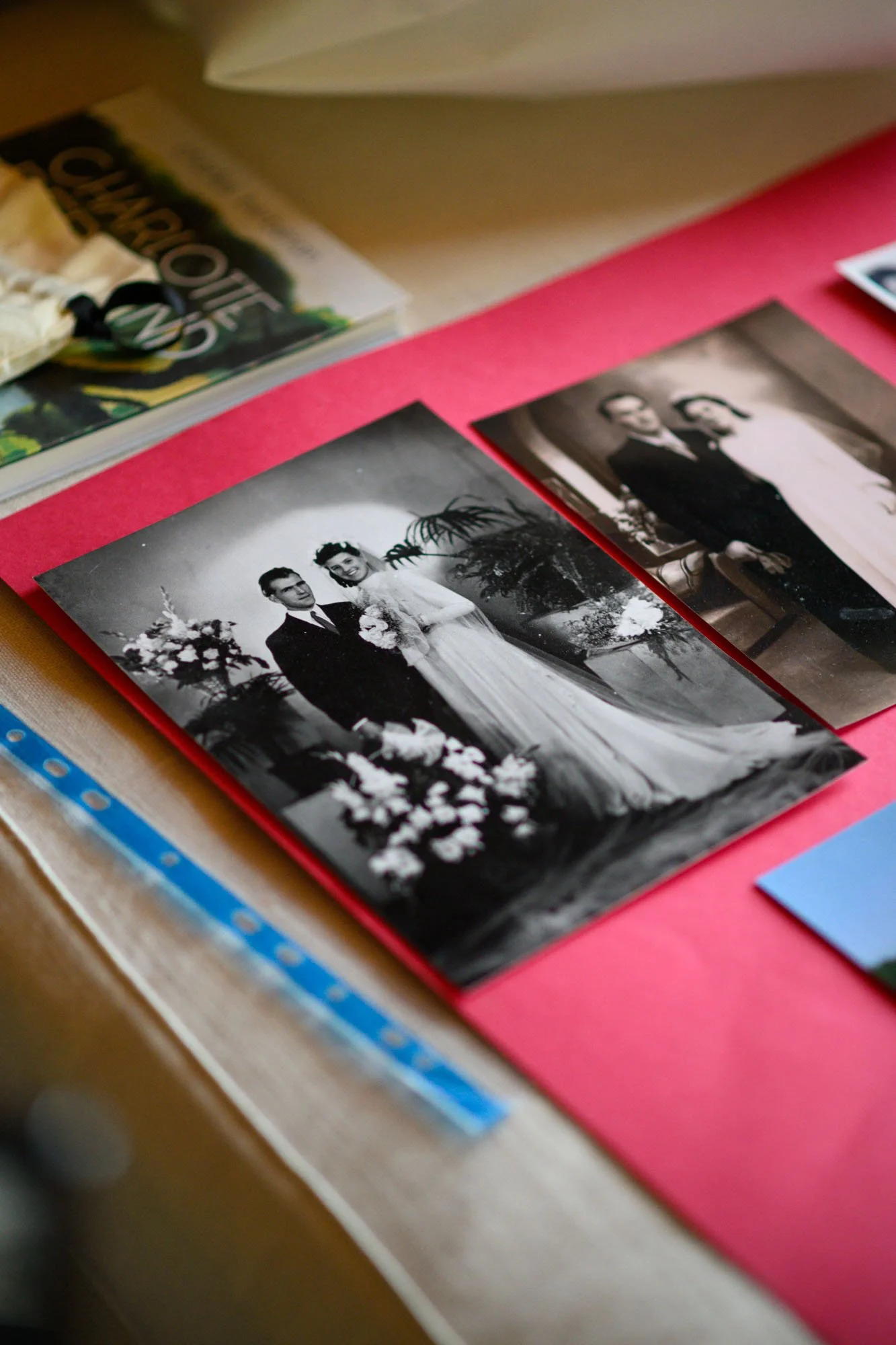 Photo en noir et blanc d'un couple marié posant lors d'un mariage, avec des fleurs et une décoration florale en arrière-plan.