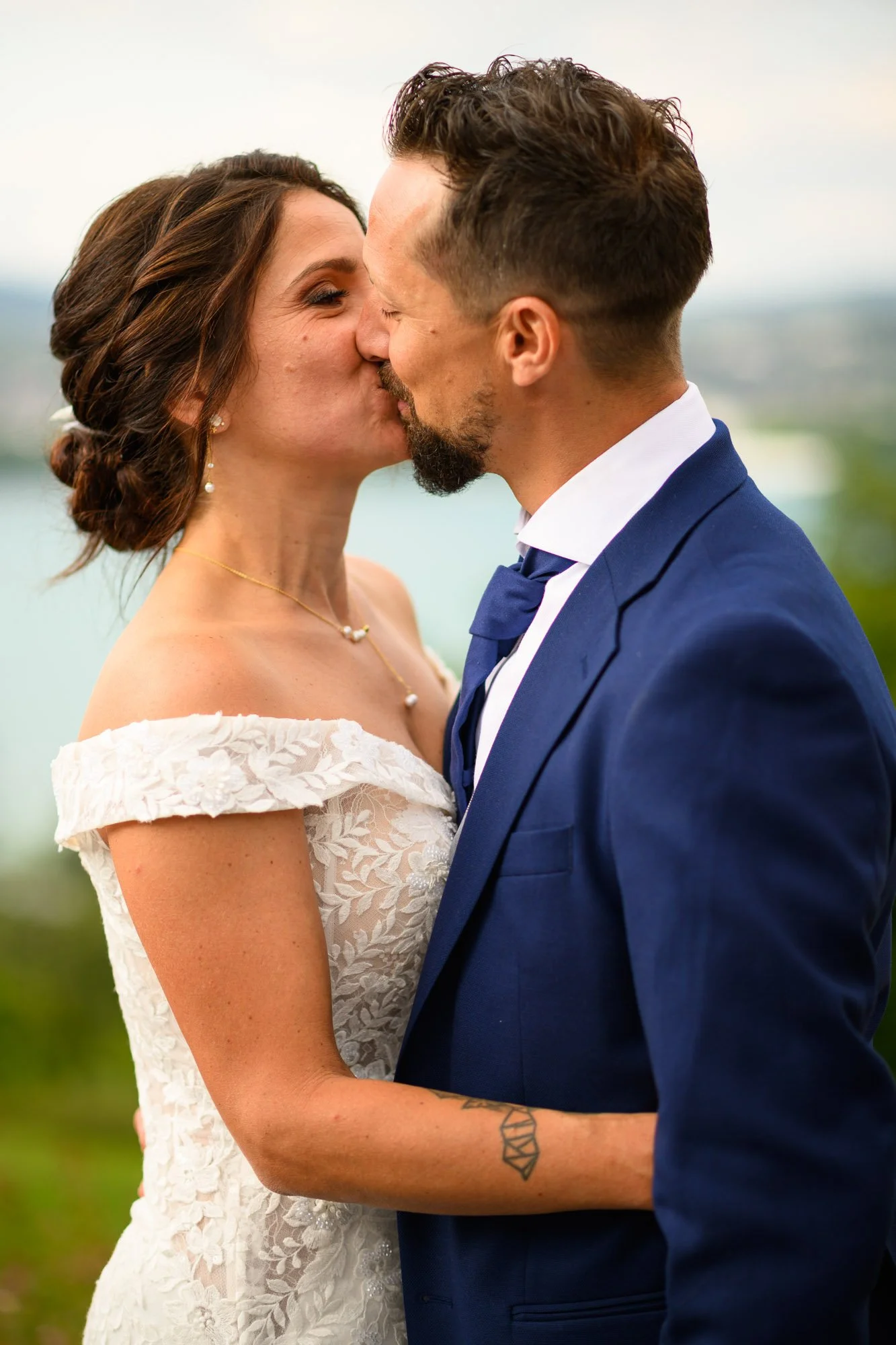 Un couple en costume de mariage s'embrassant lors de leur cérémonie.