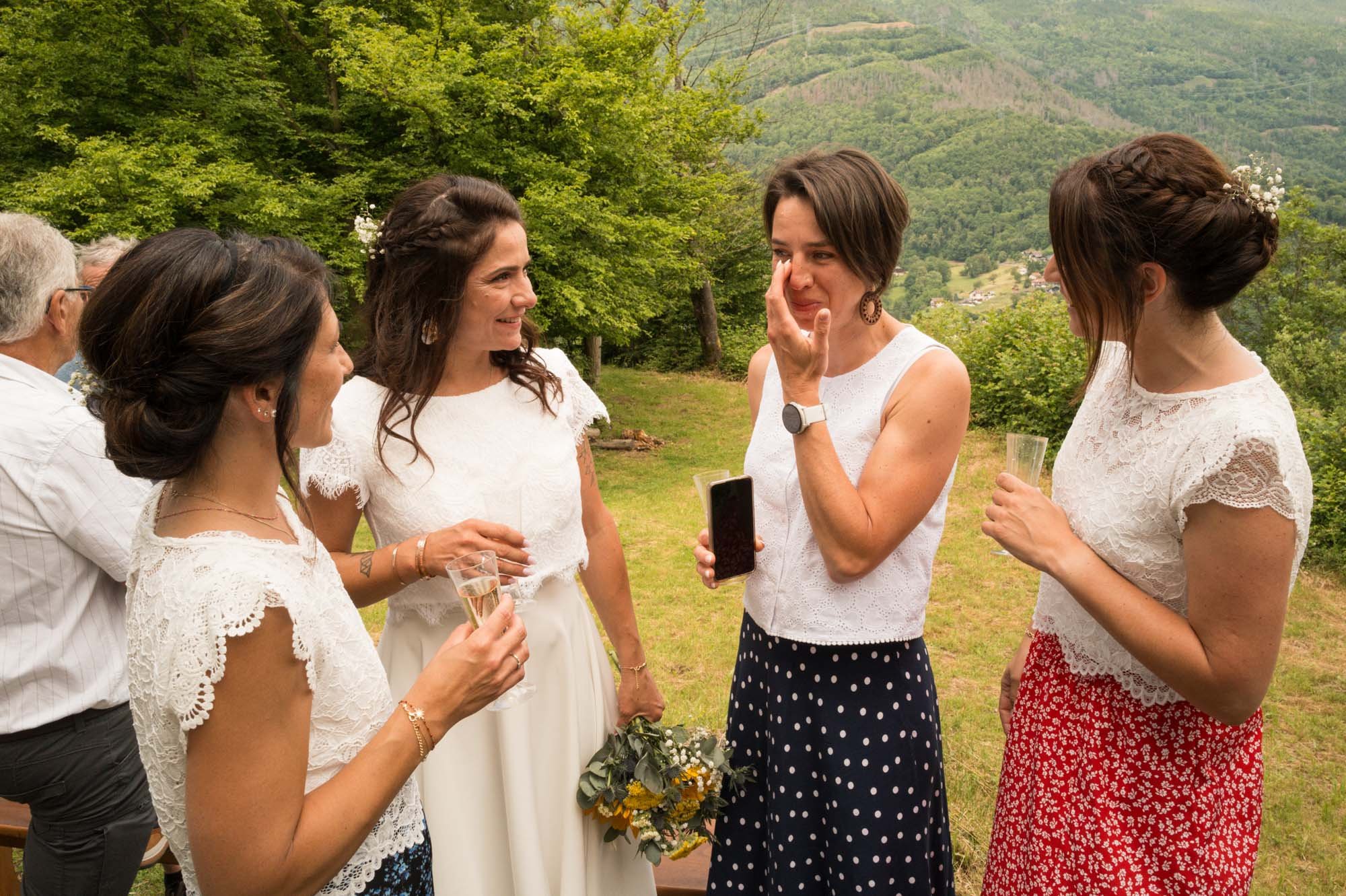 Groupe de femmes et d'hommes lors d'un événement en plein air, avec des montagnes en arrière-plan, célébrant ou partageant un moment convivial.