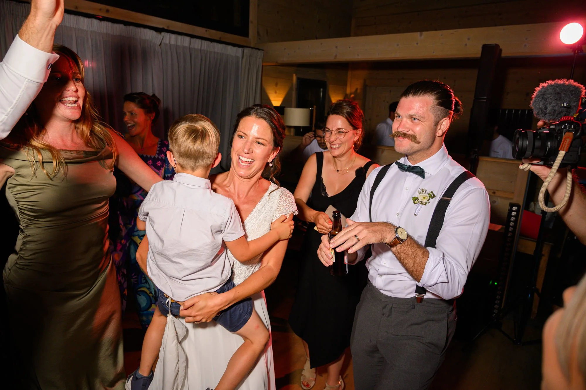 Groupe de personnes souriantes à une fête, organisant une fête dans une ambiance chaleureuse avec un décor en bois.