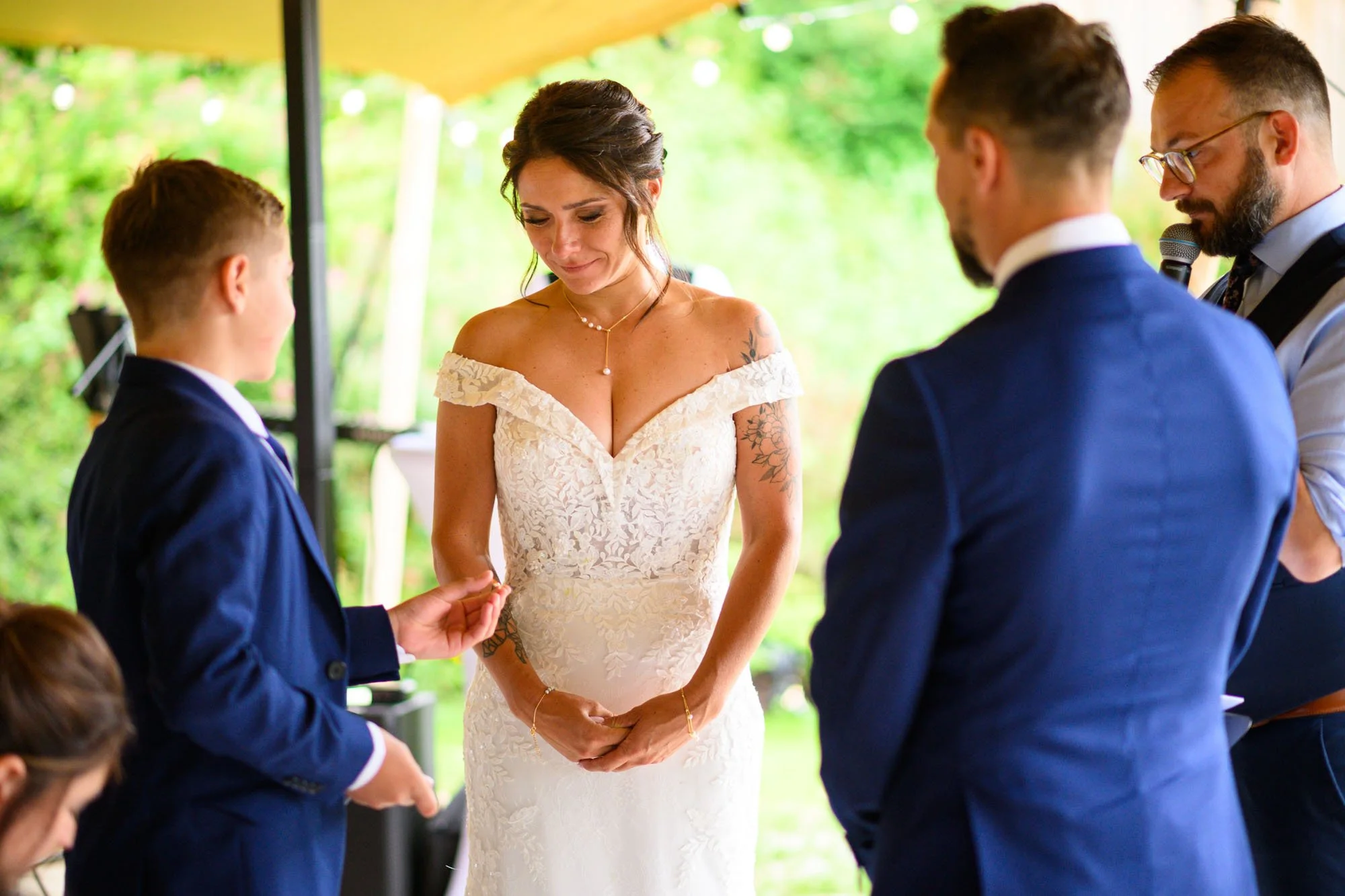 Une femme en robe de mariée pleure lors d'une cérémonie de mariage entourée de plusieurs hommes en costume