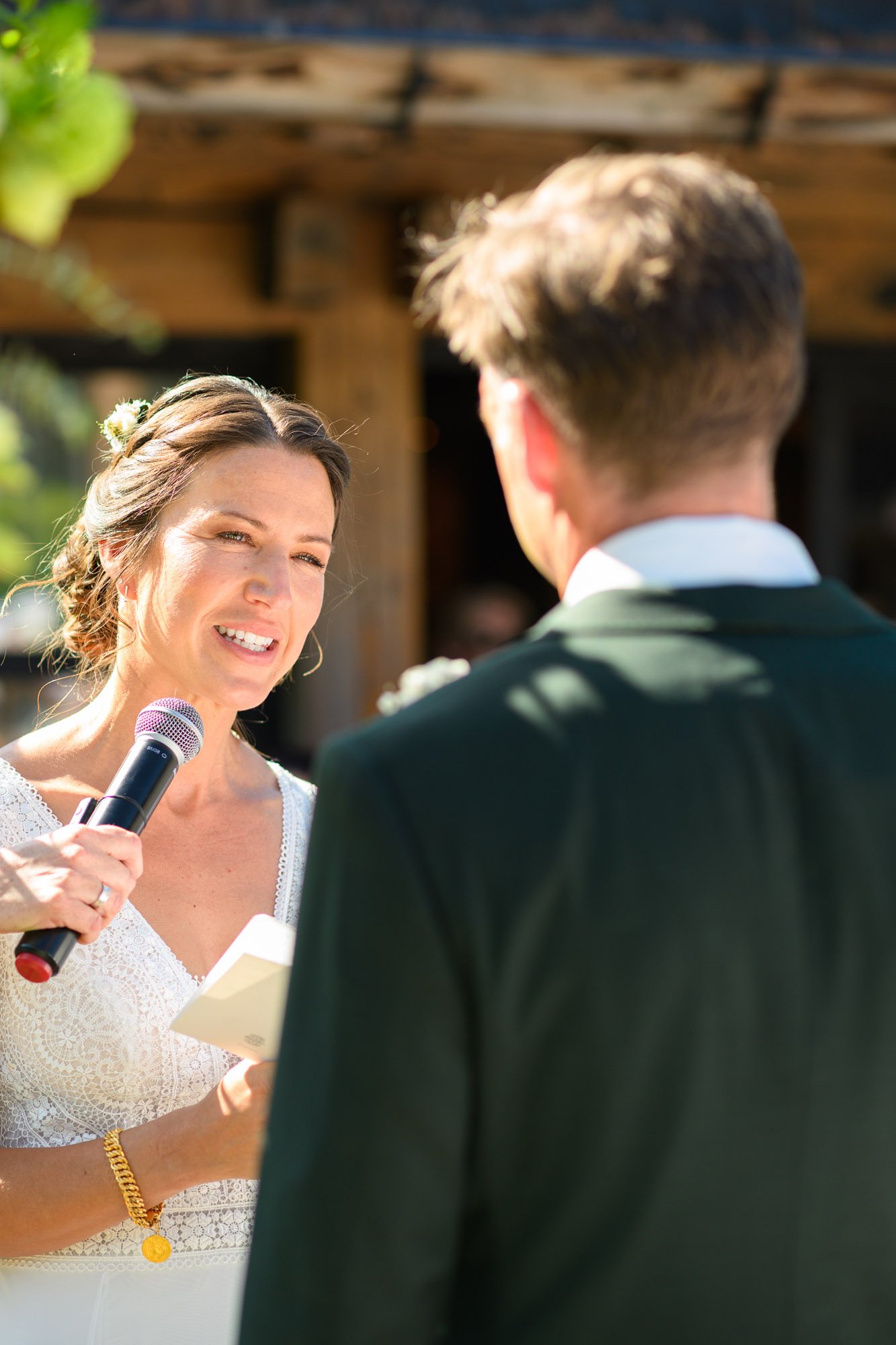 Une femme tenant un micro, en train de se marier à un homme lors d'une cérémonie en plein air.