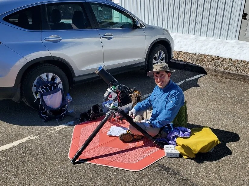 Brendan Alex Phoenix with camera setup for the 2024 April 8th total solar eclipse in the parking lot of Bethel Church in Oakfield, Maine.