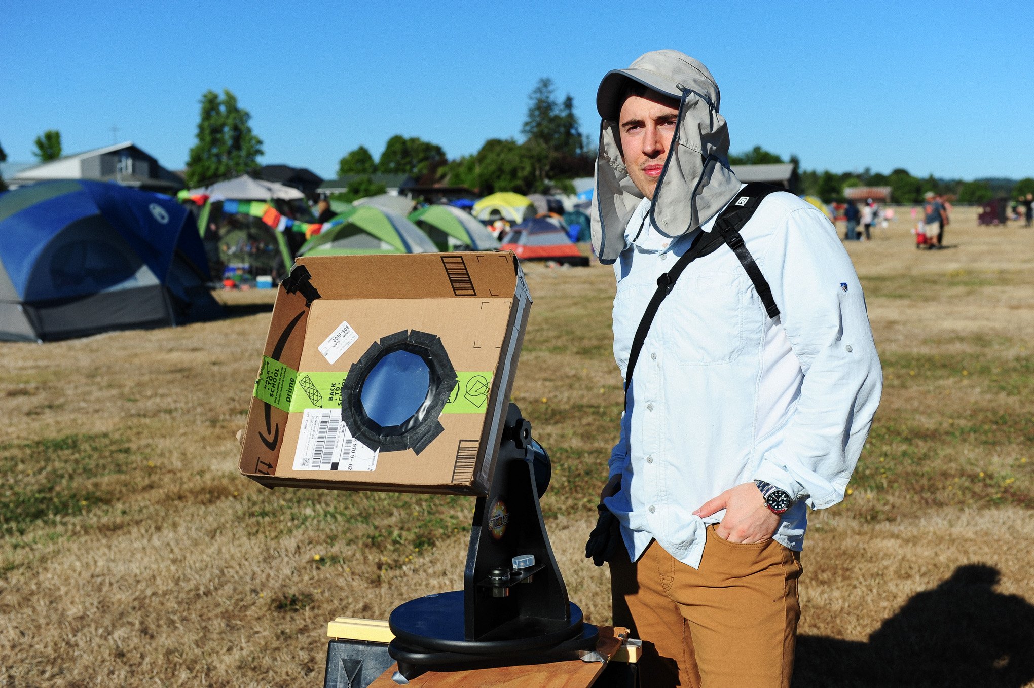 Artist Brendan Alex Phoenix standing next to a telescope in a field in Oregon waiting for the total solar eclipse. August 21st, 2017.