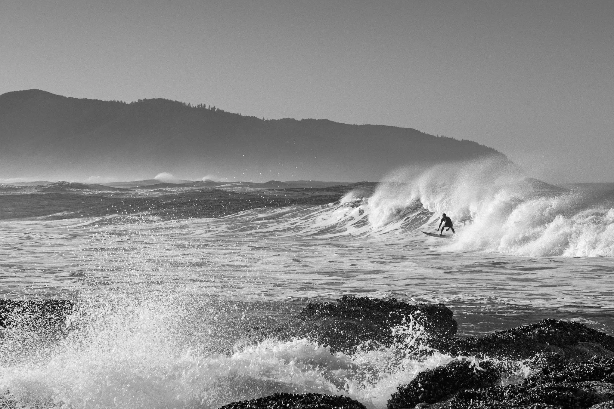 surfers-charge-black-and-white-surfer-riding-wave-cape-kiwanda-pacific-city-oregon-coast-winter-surfing-ocean-spray-landscape-photography-brendan-alex-phoenix.jpg