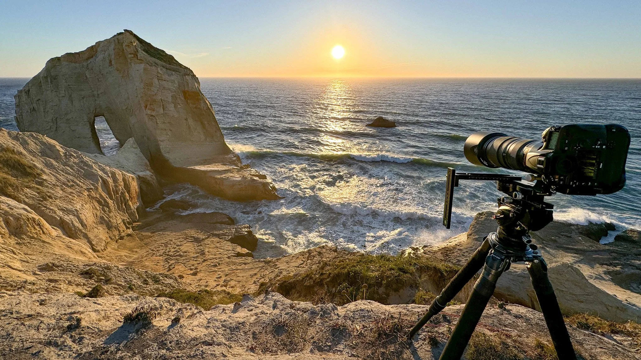 On-location photograph at Cape Kiwanda on the Oregon Coast, showing Brendan Alex Phoenix’s camera set up to capture sunlight reflecting off the ocean, the foundation for creating original BAPstracts abstract photography.