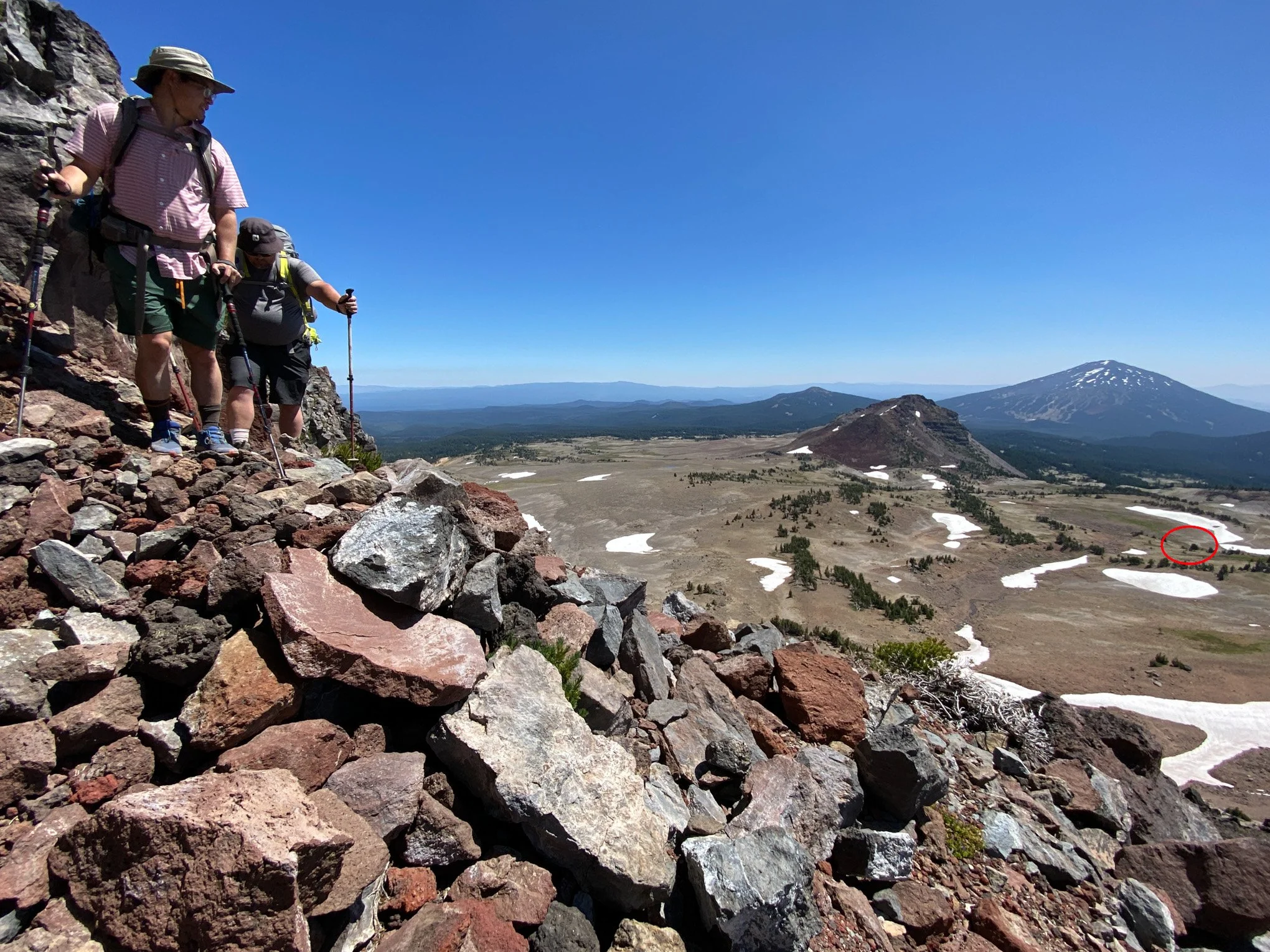 Hikers traverse volcanic rock on the Broken Hand ridgeline, part of the Broken Top Loop.