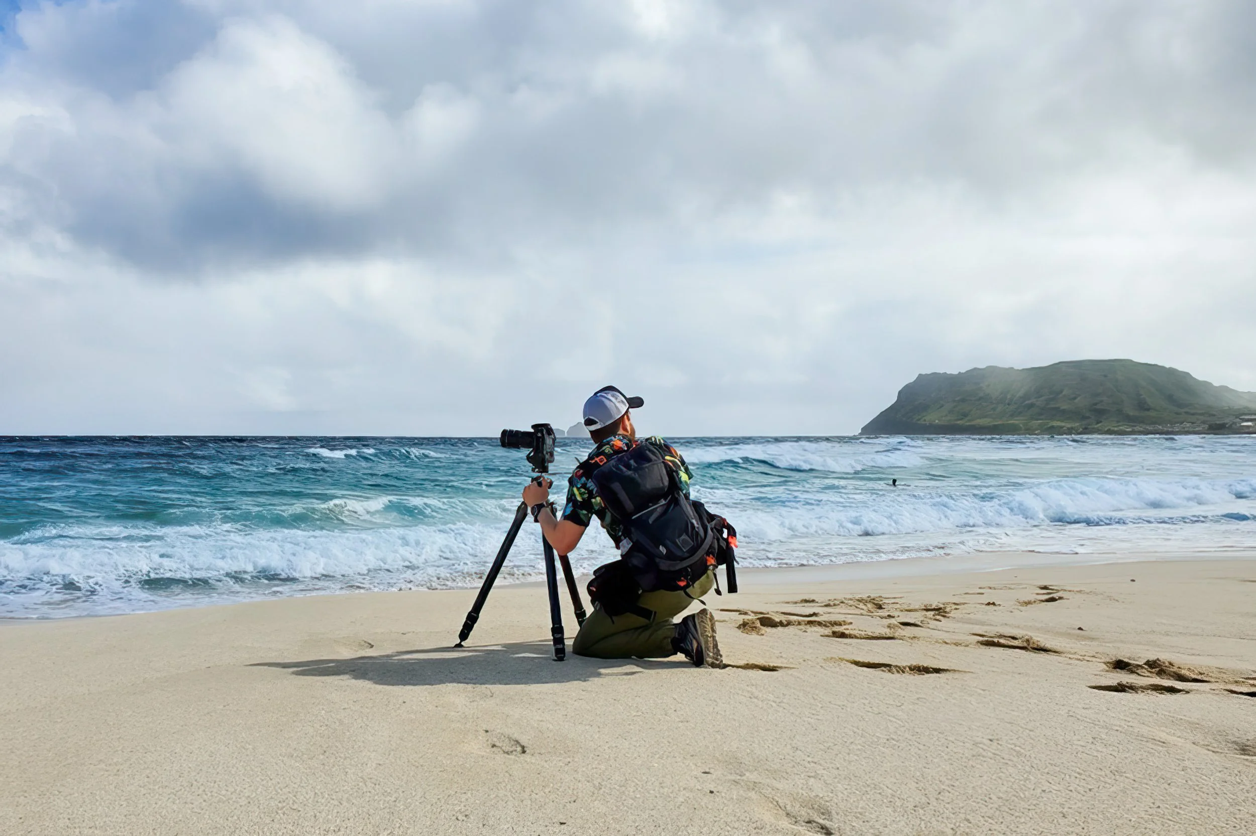 Brendan Alex Phoenix photographing at Pyramid Rock Beach on Marine Corps Base Hawaii, positioned at the waterline to time each frame with the shifting waves and light.