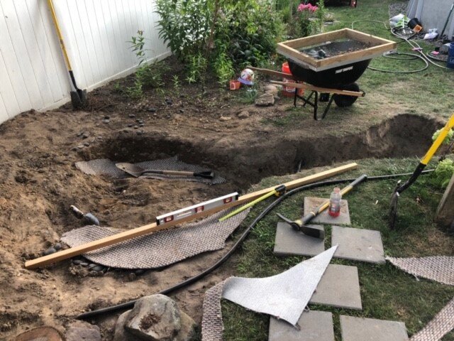 Notice thin board with level, as well as wheelbarrow with screen for pebbles