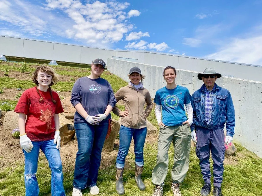 Volunteers pose in front of the garden after planting day