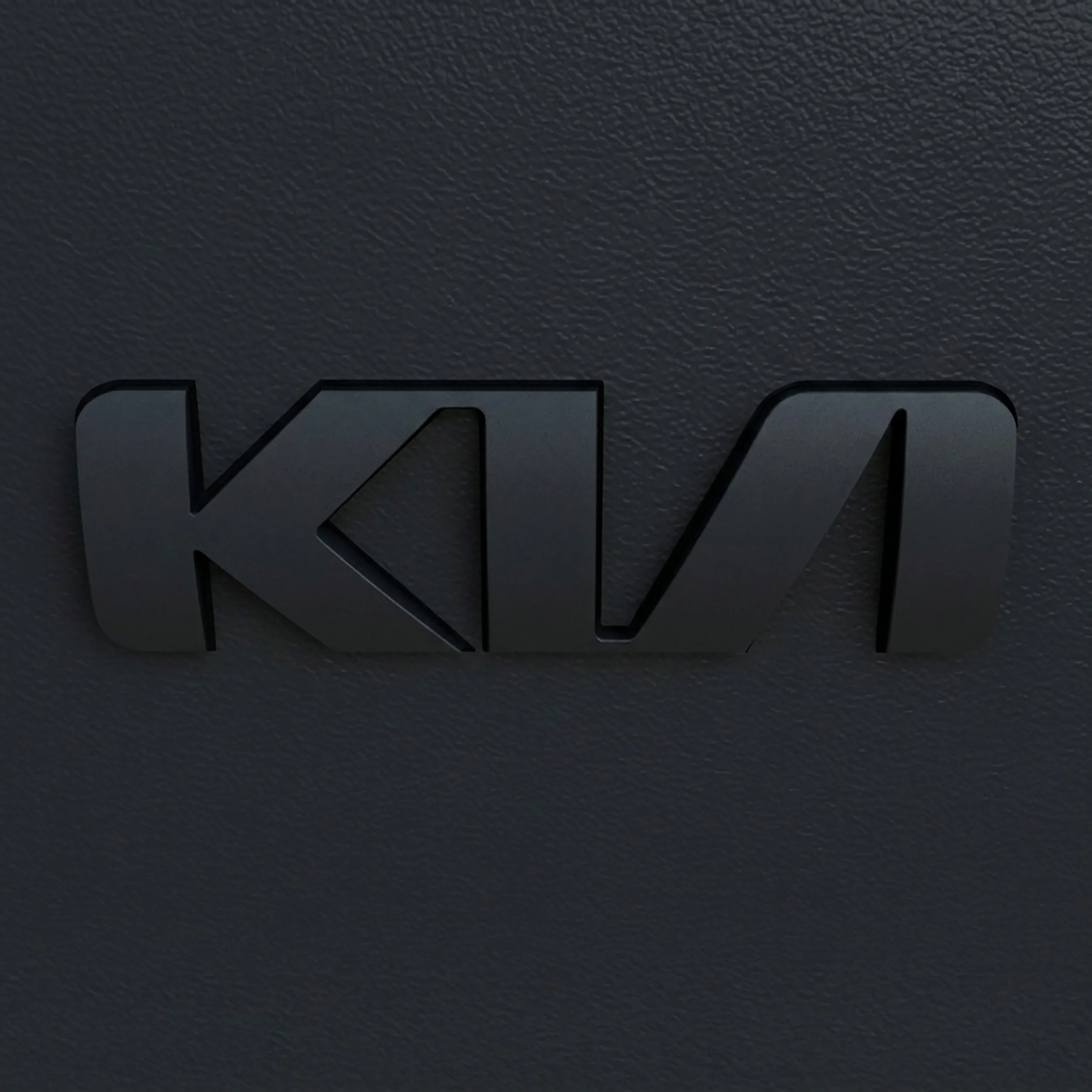 kia-car-badge-no-holding-shape-black-molded-in-straight-view-2500-2500.jpg