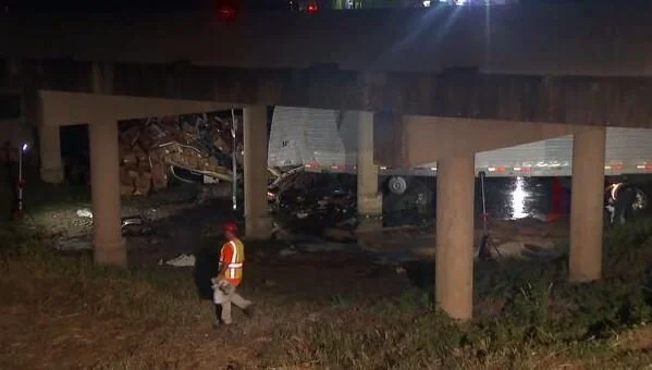 An 18-wheeler sits in a creek after it overturned on State Highway 80 Wednesday morning in Terrell. (KXAS-TV)