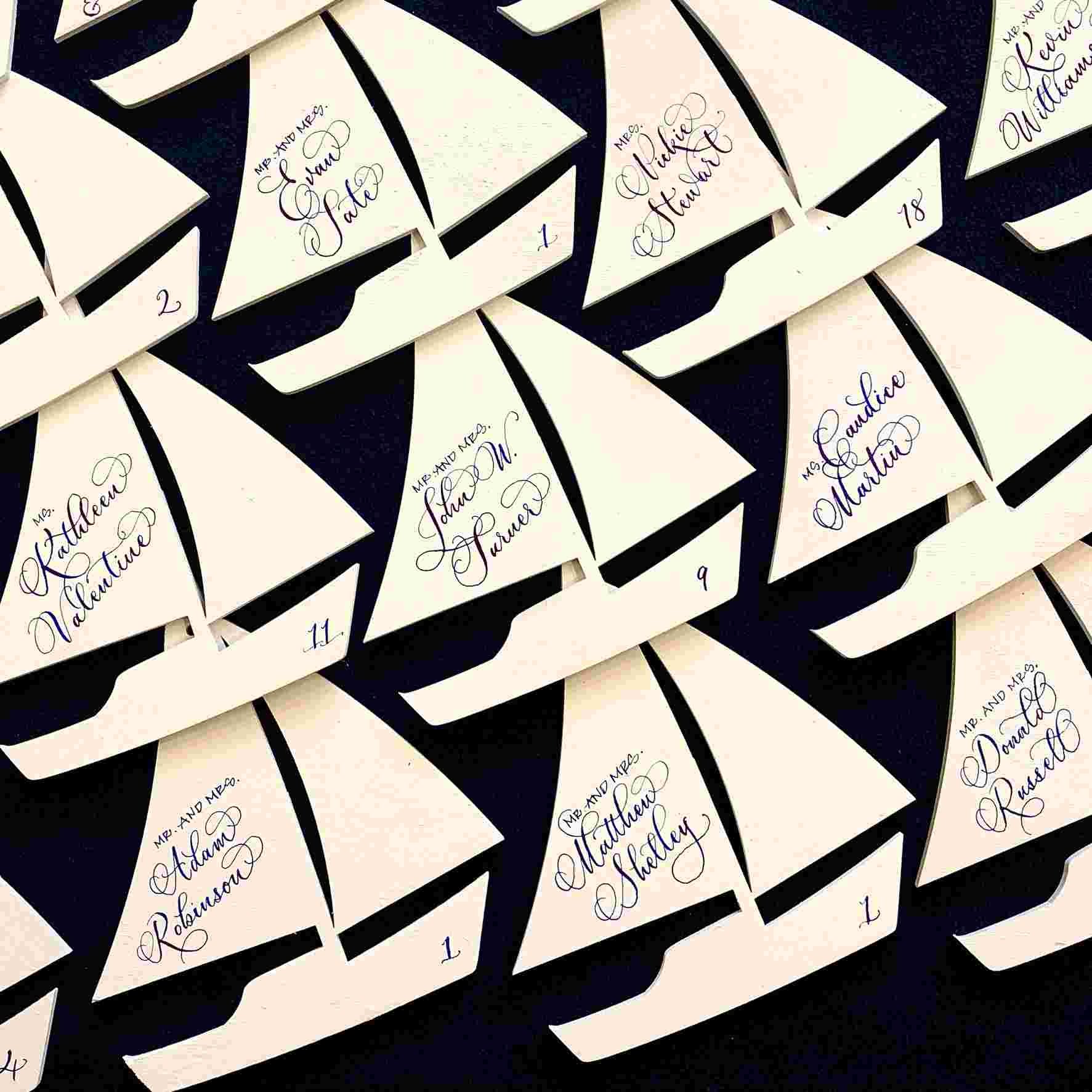 Wooden sailboat escort cards for a nautical themed wedding