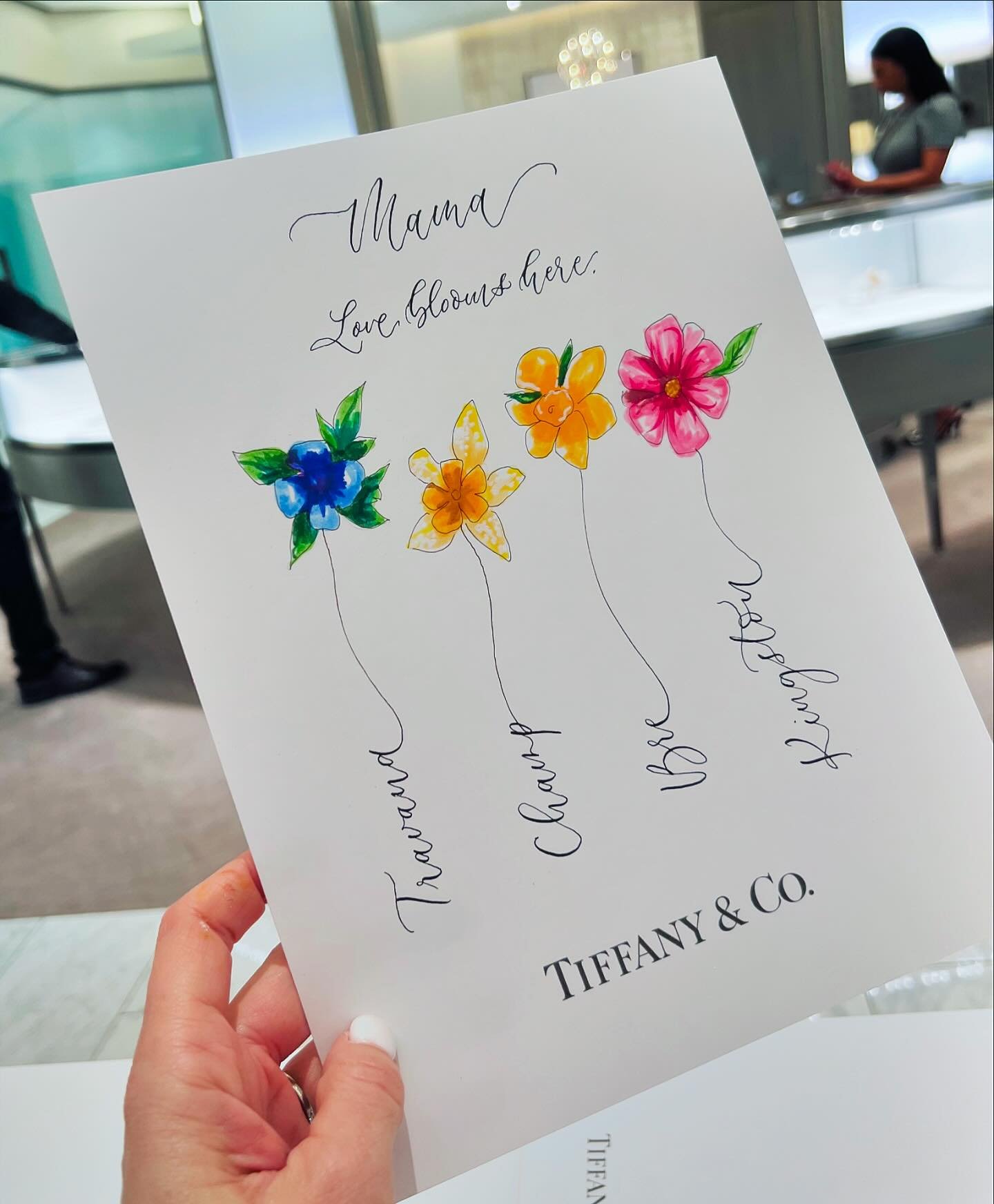 🩵 @tiffanyandco 🩵 Making mothers happy since 1837! Mother&rsquo;s Day shoppers were treated to such a special live art experience this past weekend. I wrote in calligraphy each child&rsquo;s name, then I added the coordinating birth month  flower a
