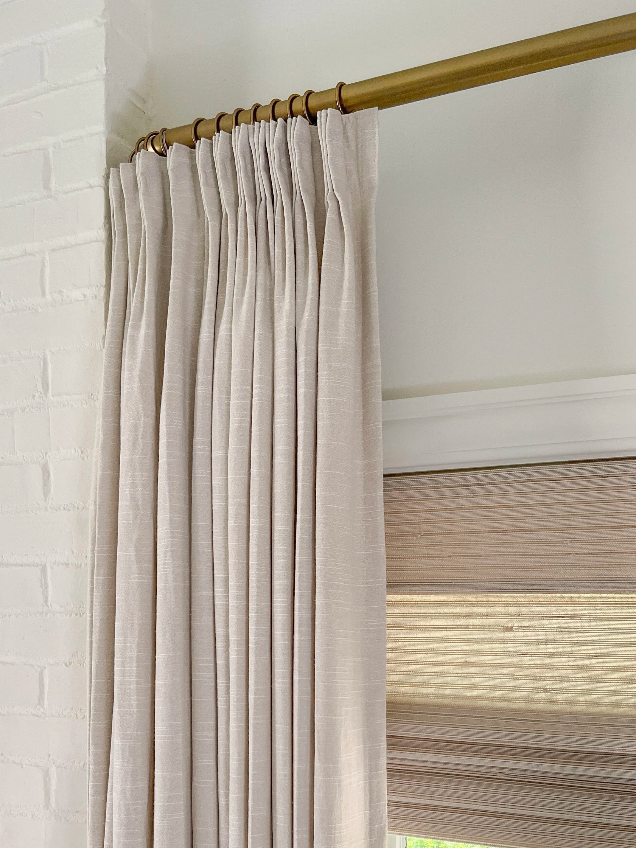 Brass French return curtain rod installed close to ceiling above TwoPages floor-length panels