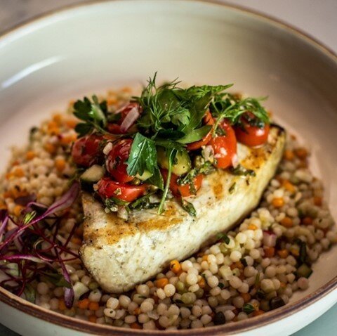 Sea you for dinner? 🌊 Drop us a line for reservations, and snag this delicious, juicy swordfish with tomato-caper salsa on a bed of savory Israeli cous cous. #WoodFireLove