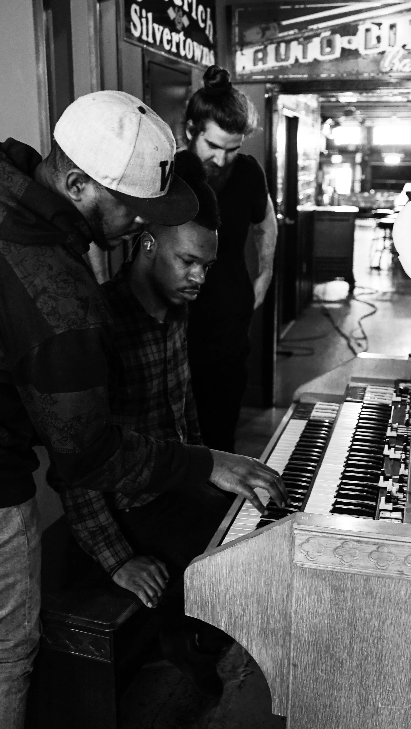 Black-and-white musicians gathered around a white piano