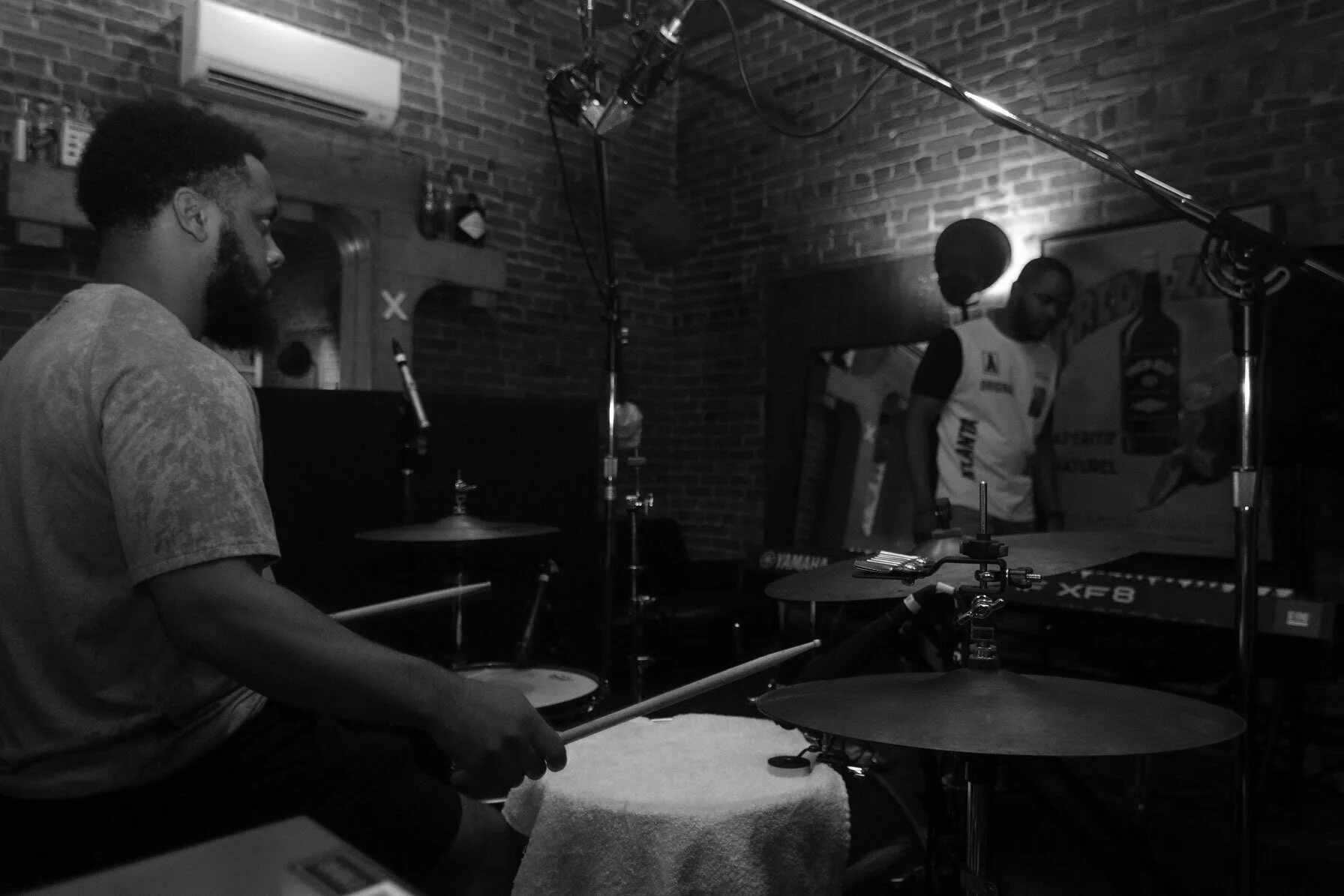Black-and-white recording session with a drummer and another musician
