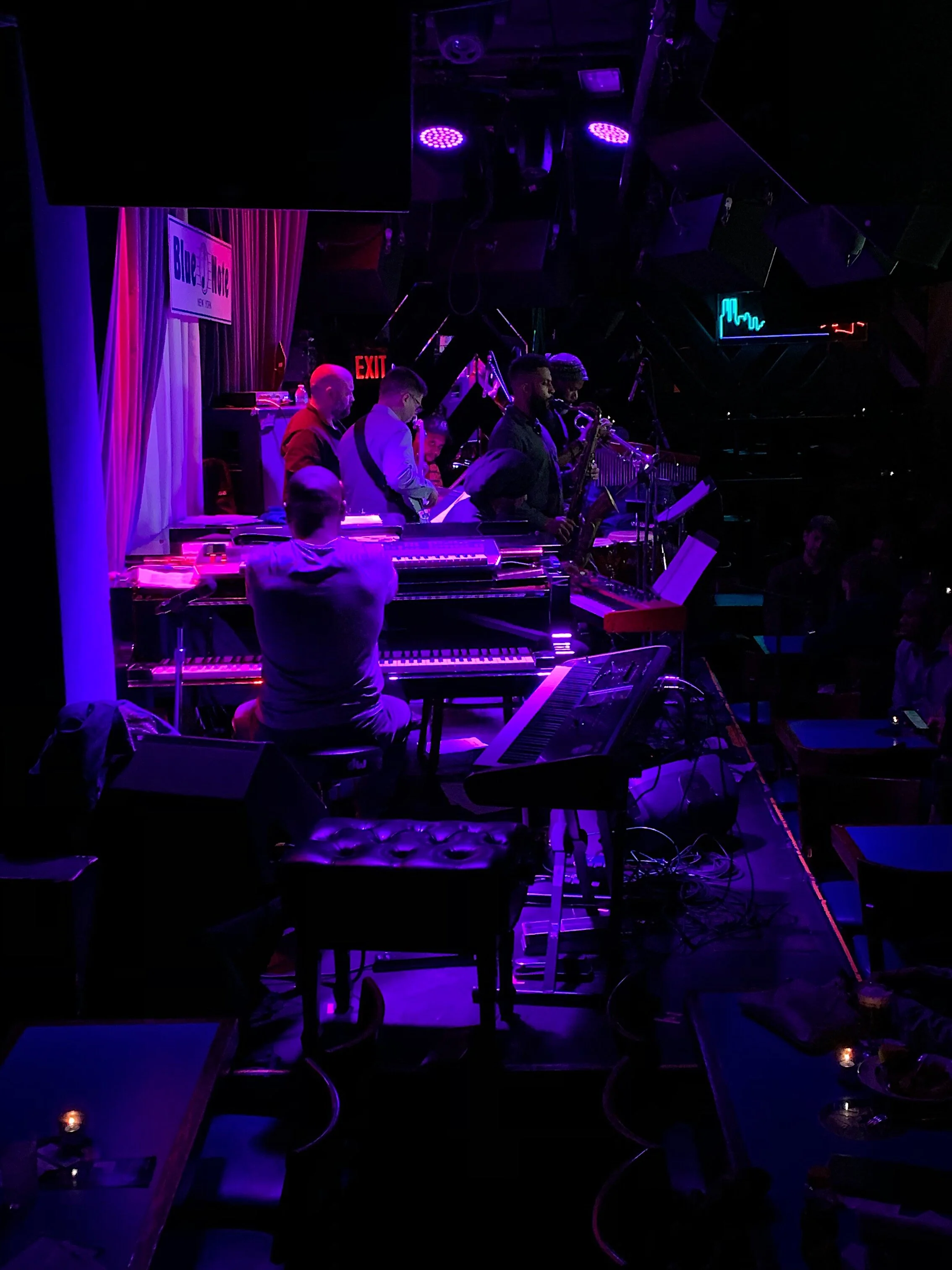 Side view of a keyboard performance under purple stage lighting