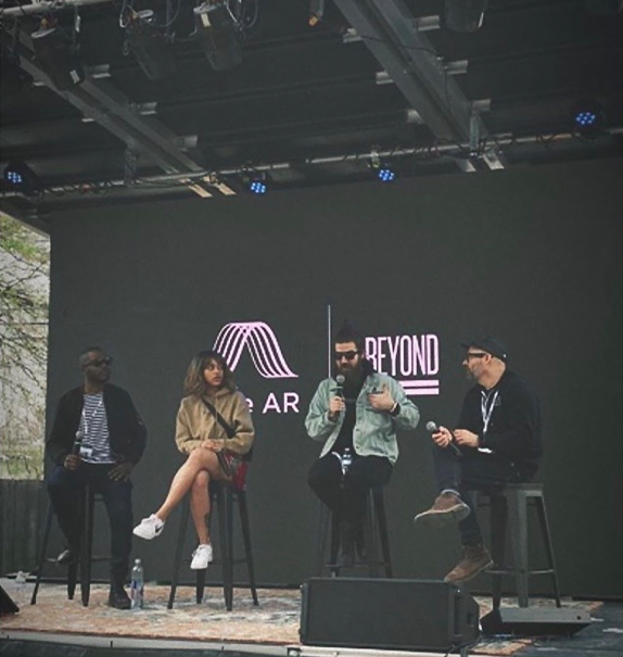 Panel discussion on an outdoor stage with Bose AR signage