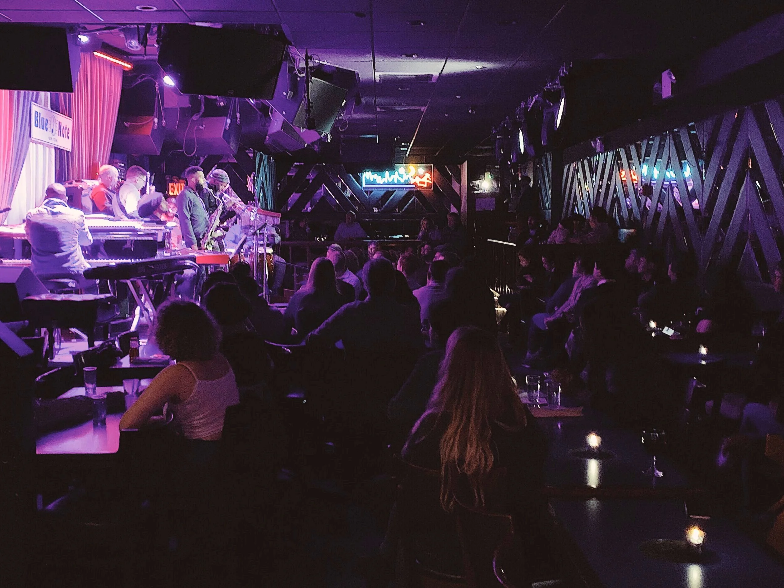 Wide view of a club performance with the audience in the foreground