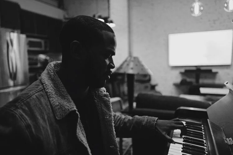 Black-and-white side profile of a pianist at the keyboard