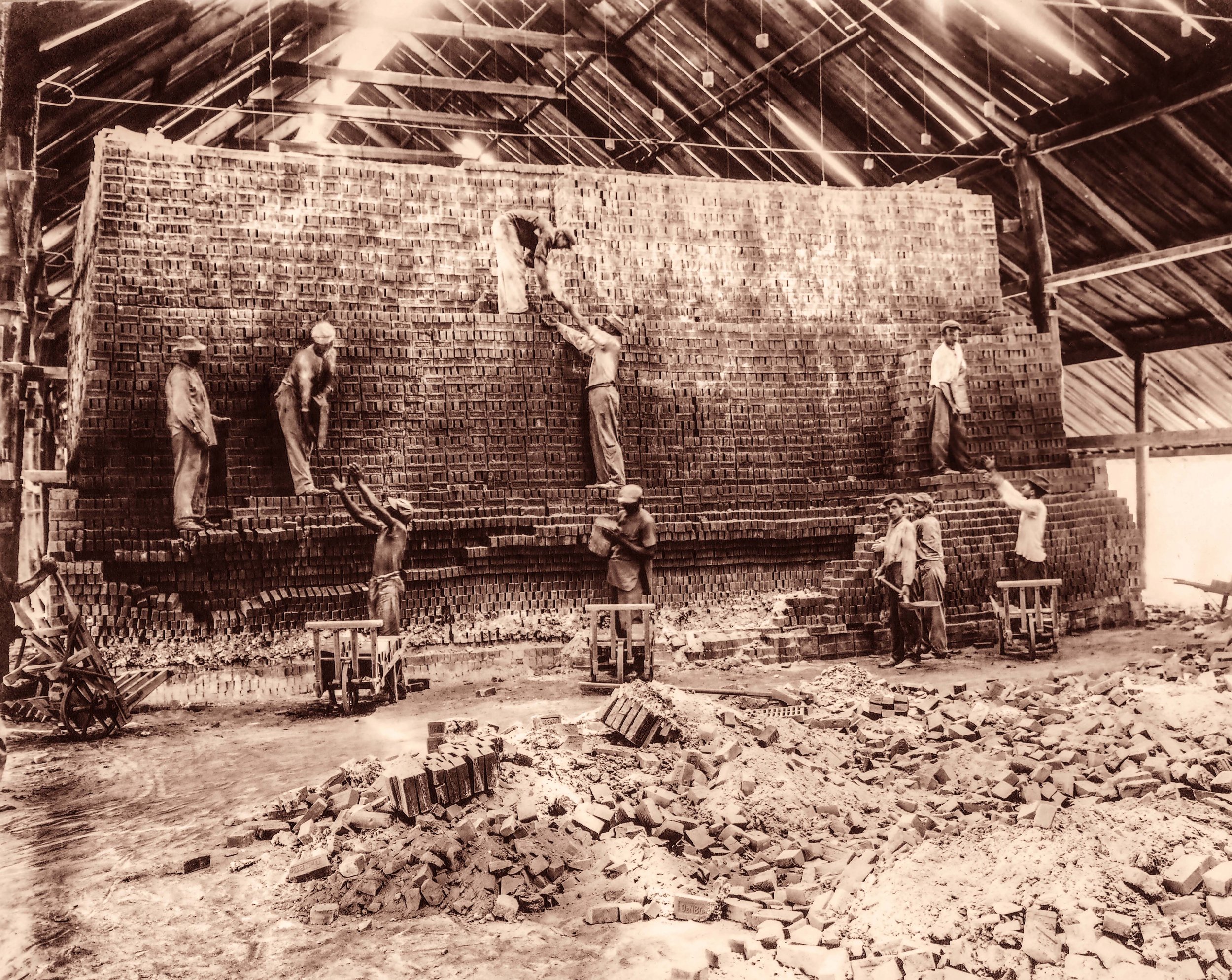 workmen tearing down brick kiln after burning 1912 sepia.jpg