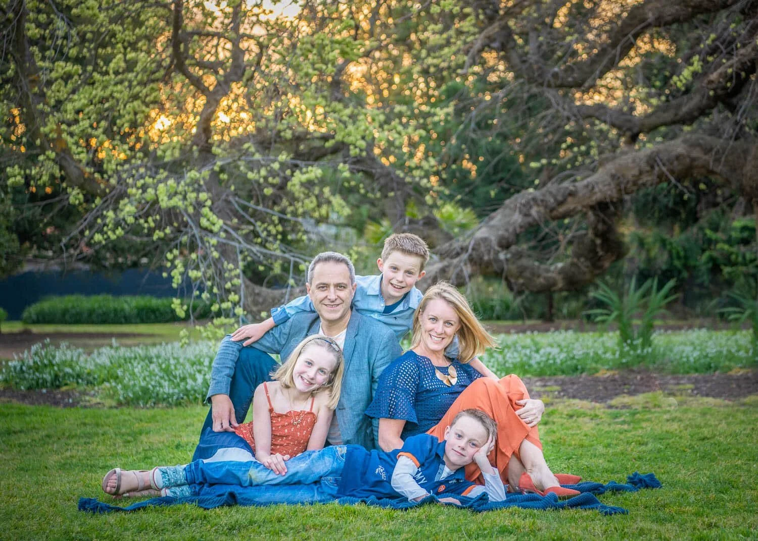 Susan Bradfield Photography family photo of a group of five dressed in orange and blue sitting happily at the park