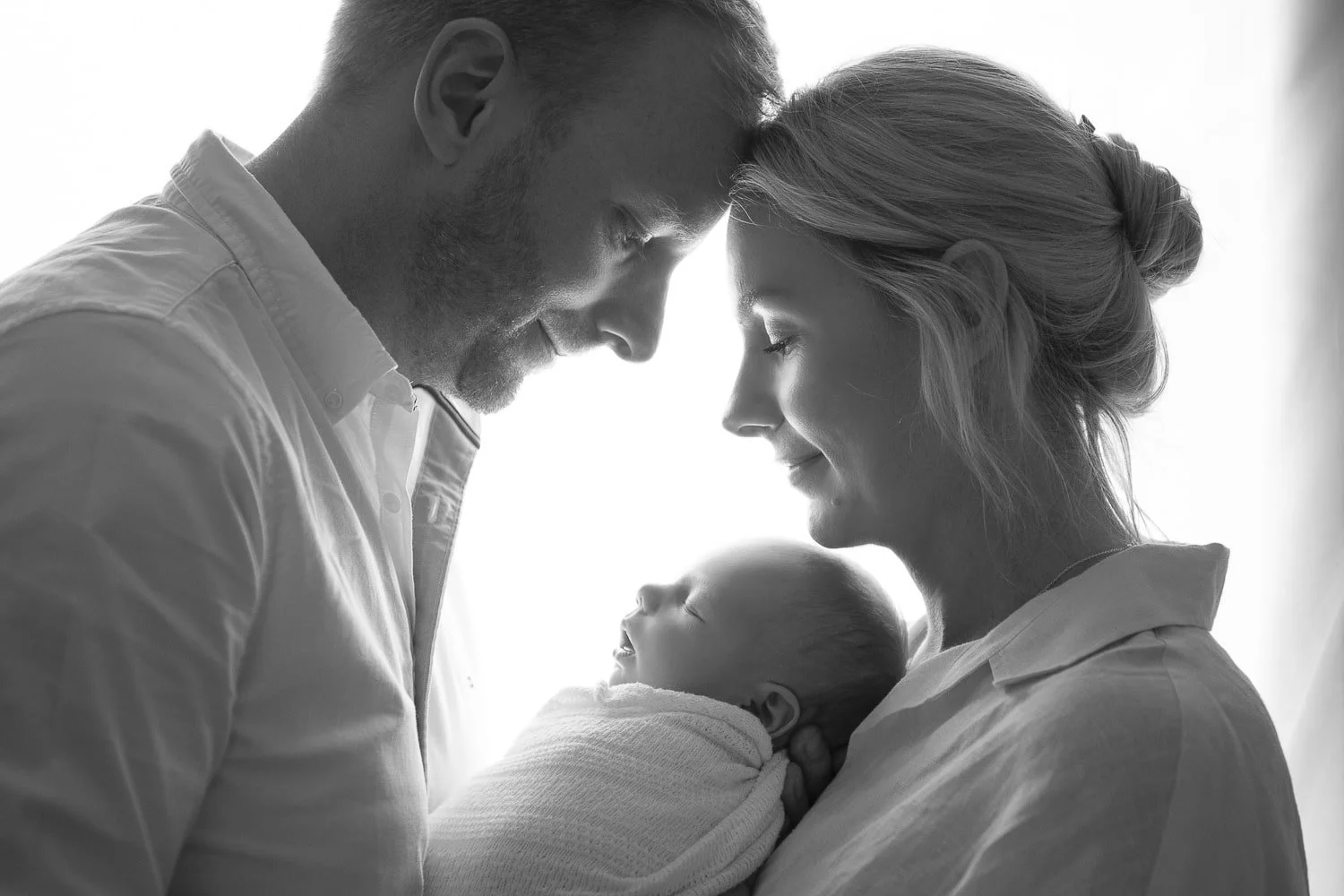 parents holding newborn during photoshoot