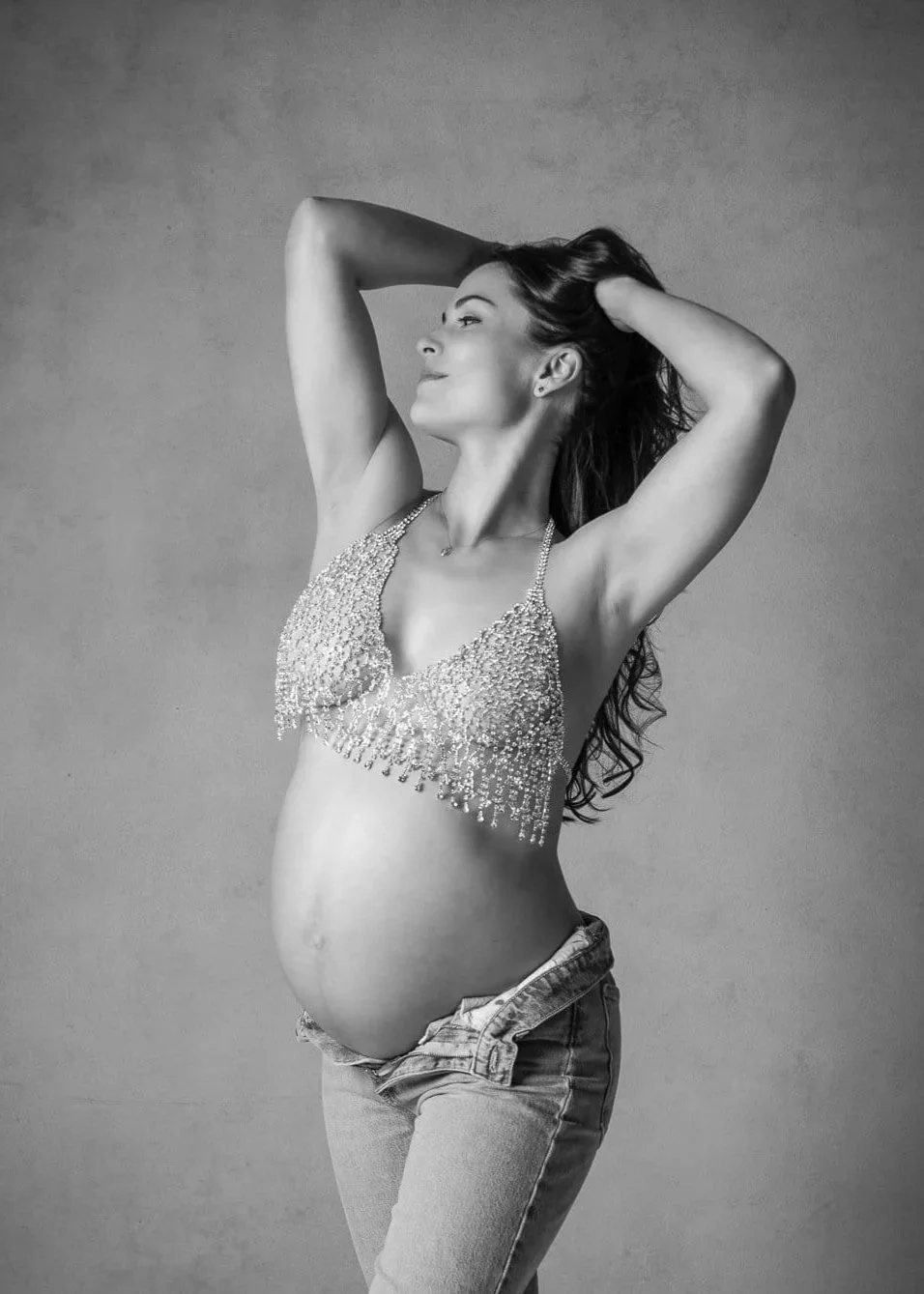 Susan+Bradfield+Photography%2C+pregnant+woman+with+arms+in+hair%2C+with+sparkly+bra+and+jeans-min.jpg