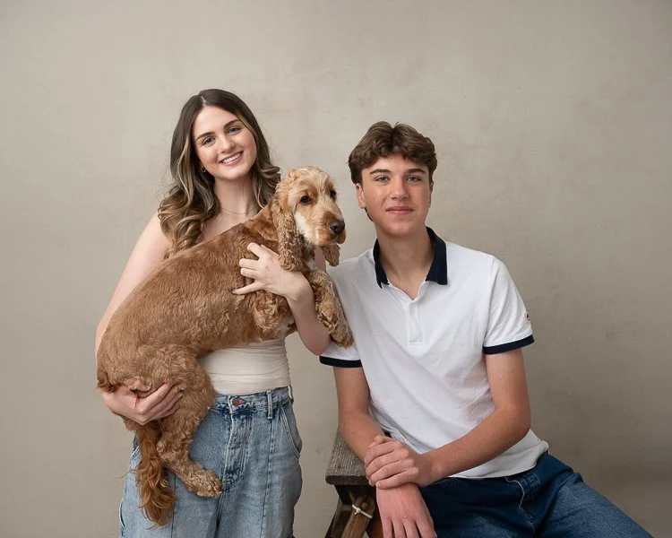 Melbourne family photographer image of a brother and sister holding a cocker spaniel dog with a neutral backdrop