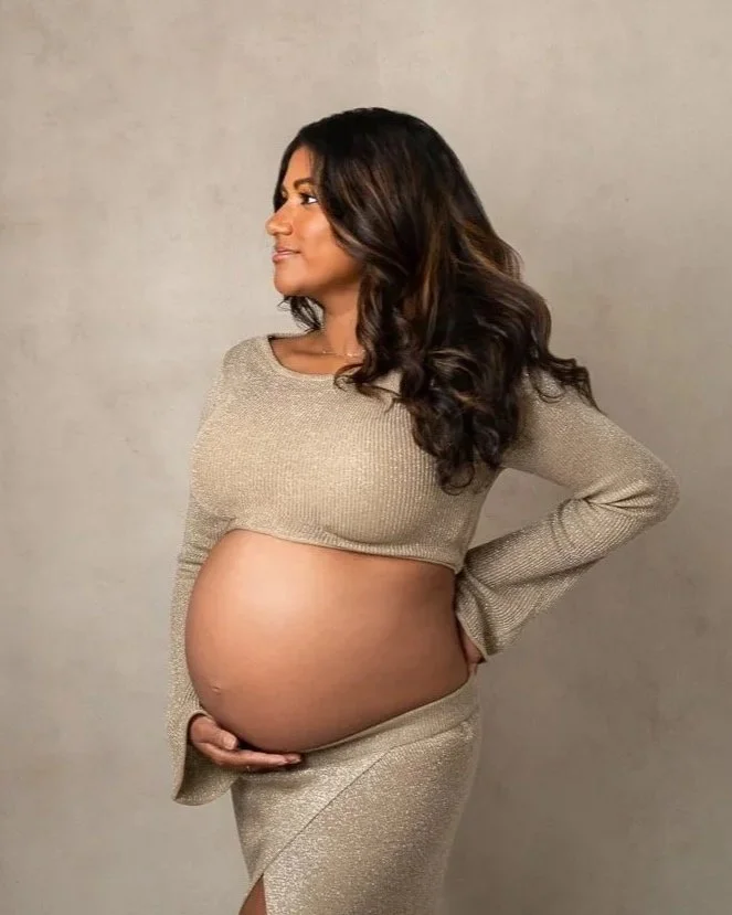 Studio photo of a Pregnant woman in a gold outfit