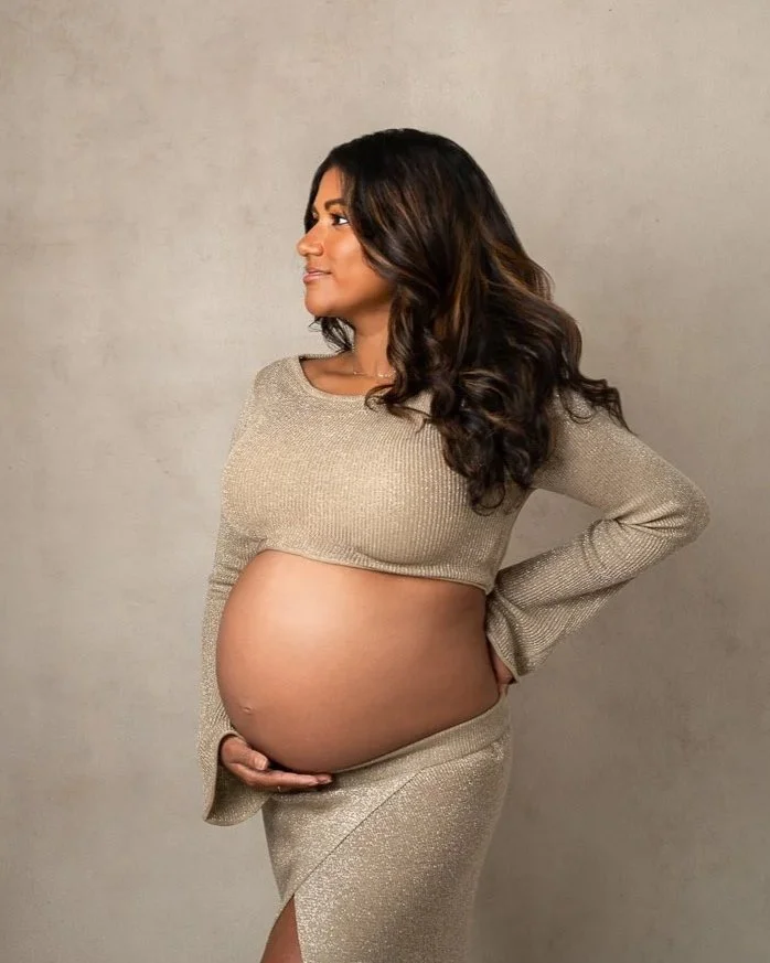 Susan Bradifeld PHotography studio maternity photo of pregnant woman wearing a gold outfit showing her pregnant tummy